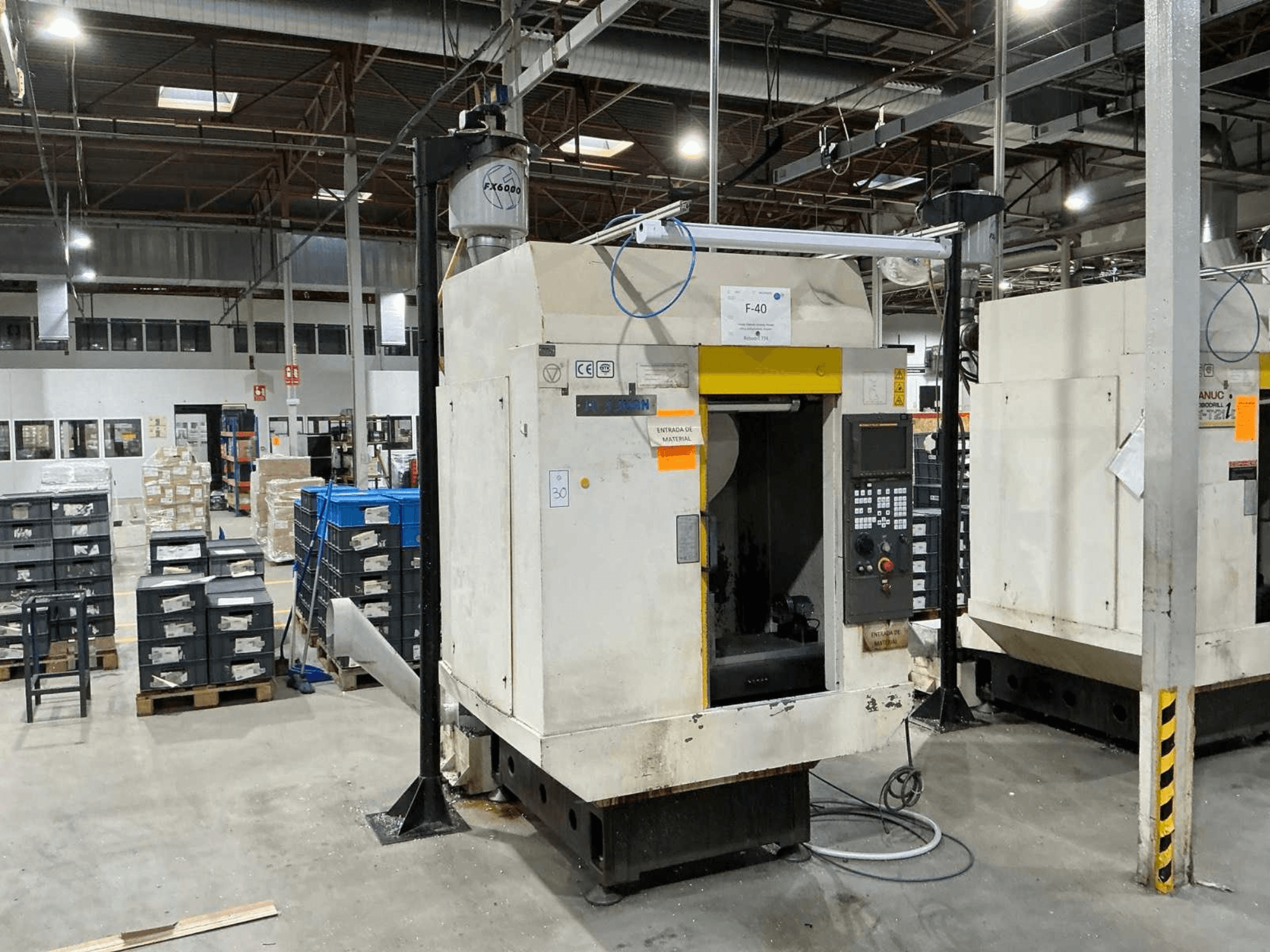 FANUC ROBODRILL α-T21iD, вигляд спереду вертикального обробного центру в промислових умовах, з деталями панелі керування.