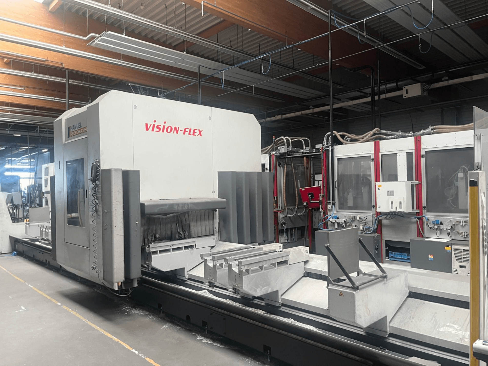 Вертикальний обробний центр Hamuel Reichenbacher Vision Flex: вид збоку, на якому видно робочу зону та елементи управління в промисловому середовищі.