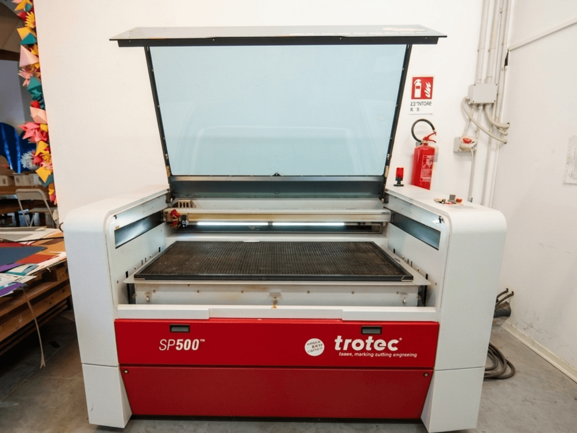 Лазерний гравірувальний верстат Trotec SP500 C200 спереду, з відкритою кришкою, на якій видно робочу зону та елементи керування.