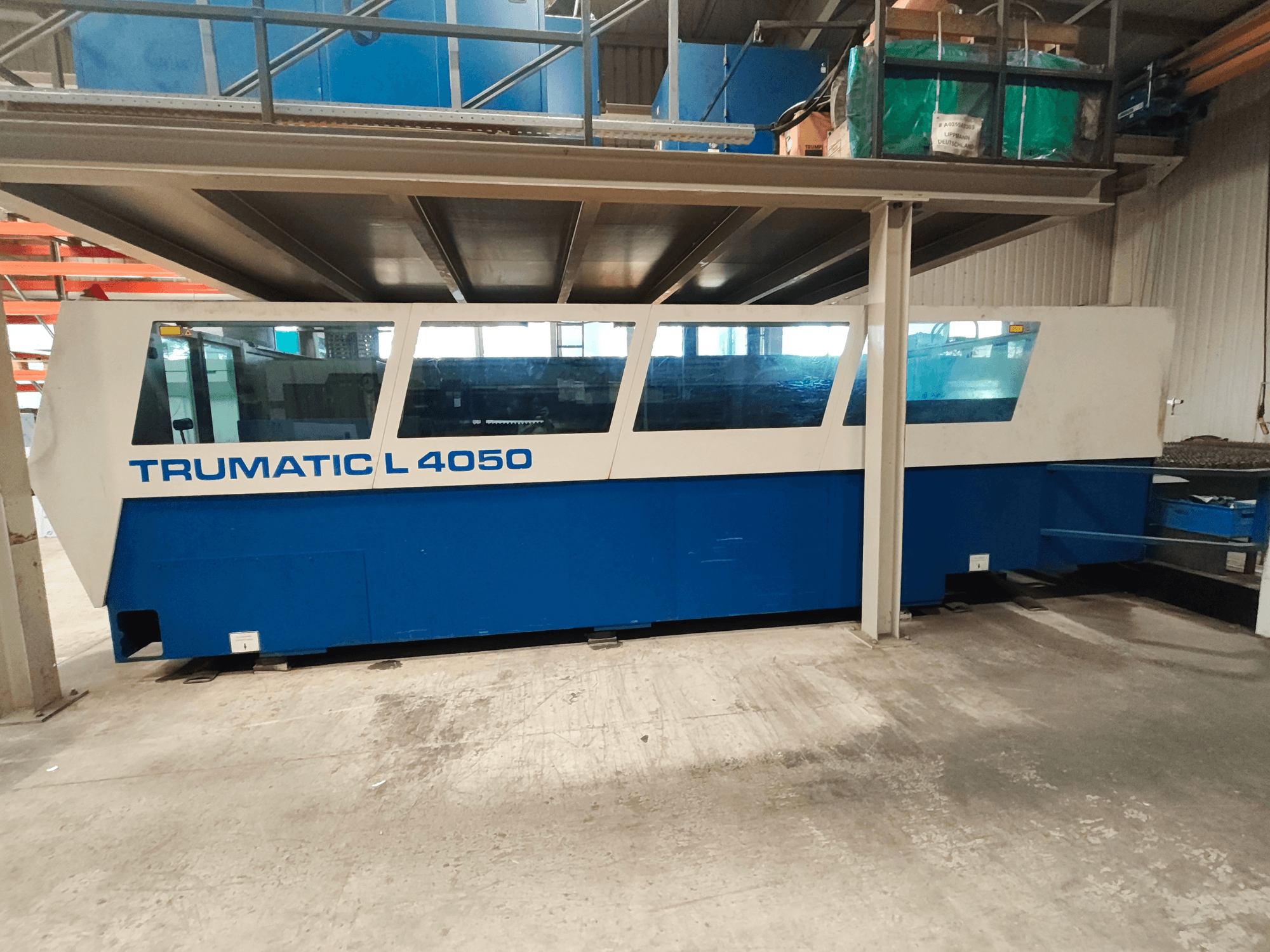 Лазерний верстат для різання CO2 TRUMPF TruLaser 450 у боковому ракурсі, виконаний у синьо-білій кольоровій гамі, з видимою панеллю керування та робочою зоною.