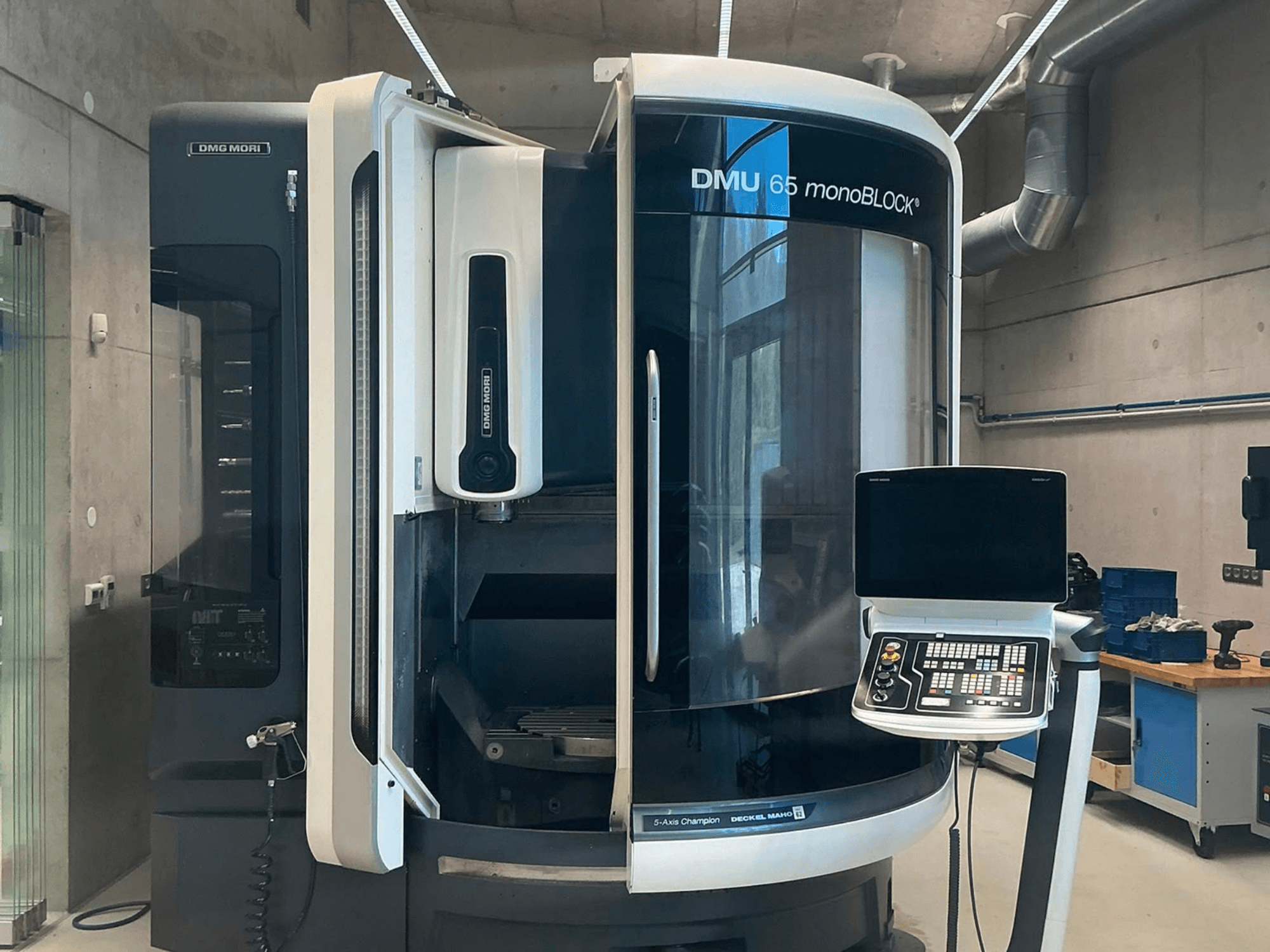 Вертикальний обробний центр DMG MORI DMU 65 monoBLOCK, вид спереду, на якому видно панель управління та деталі верстата в умовах цеху.
