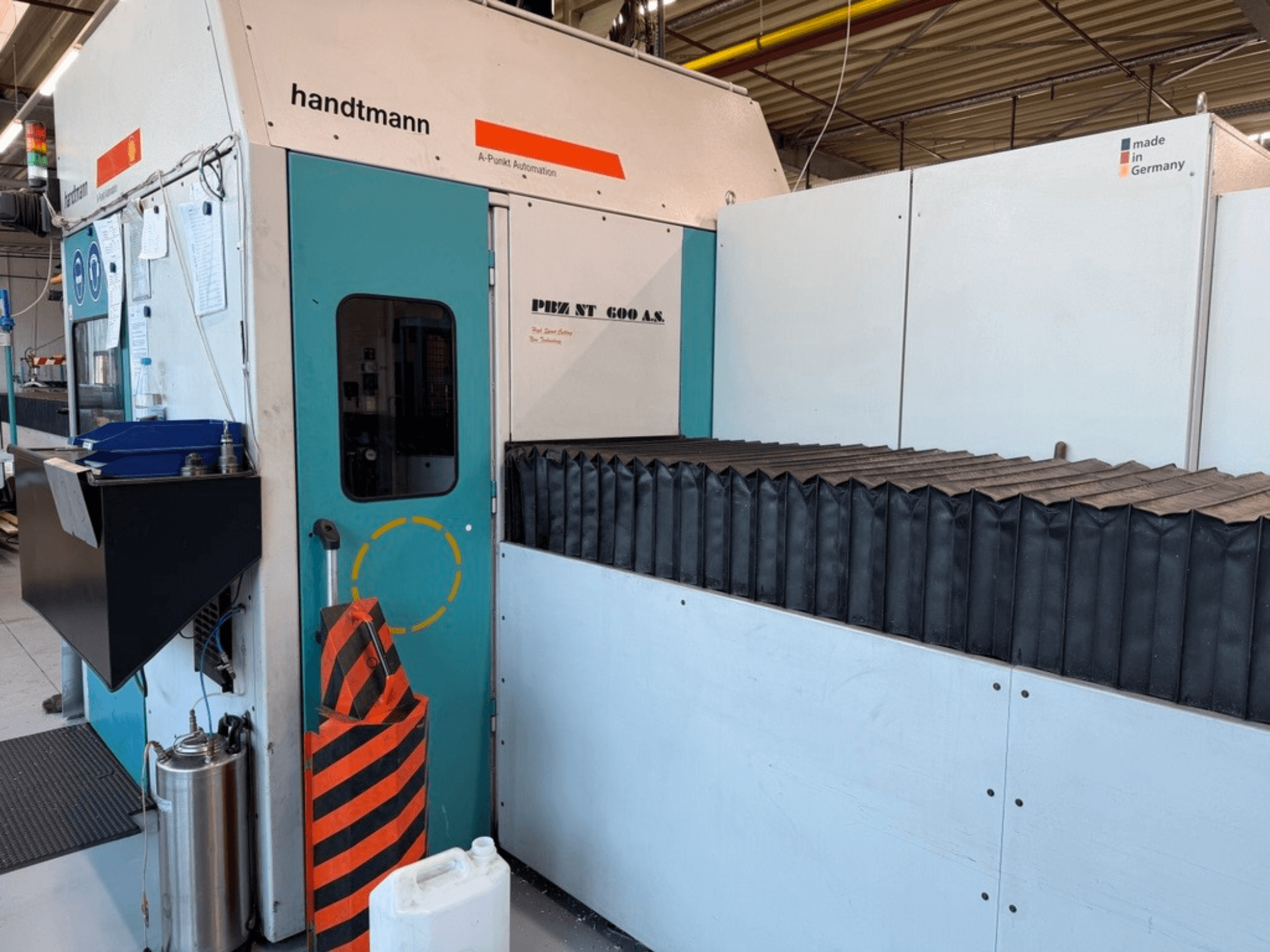 Вид спереду портального фрезерного верстата Handtmann PBZ NT 600 AS з темною робочою поверхнею та захисними огородженнями.