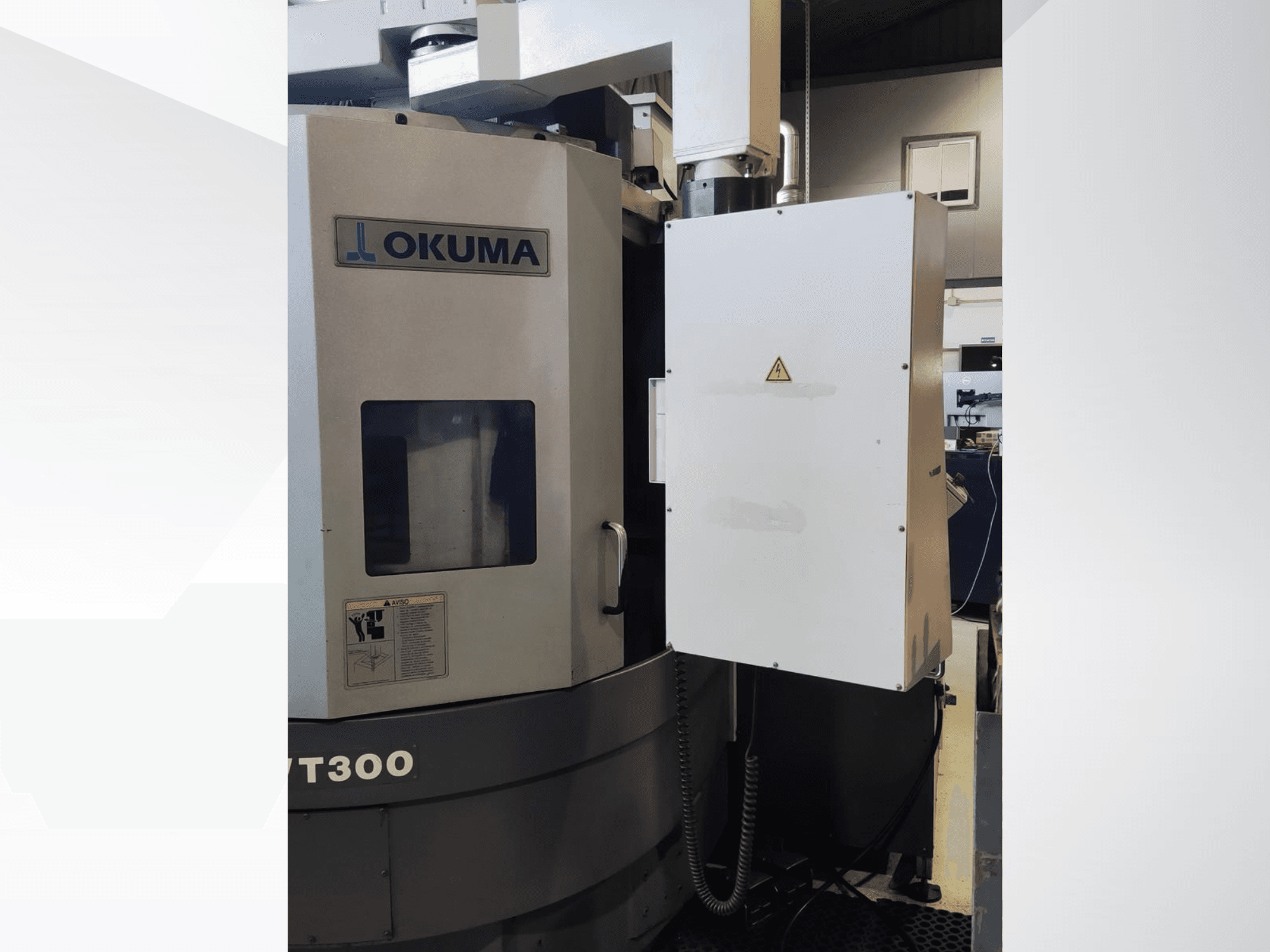 Вертикальний токарний верстат Okuma LVT300, вид спереду, демонструє панель керування та позначені елементи безпеки.