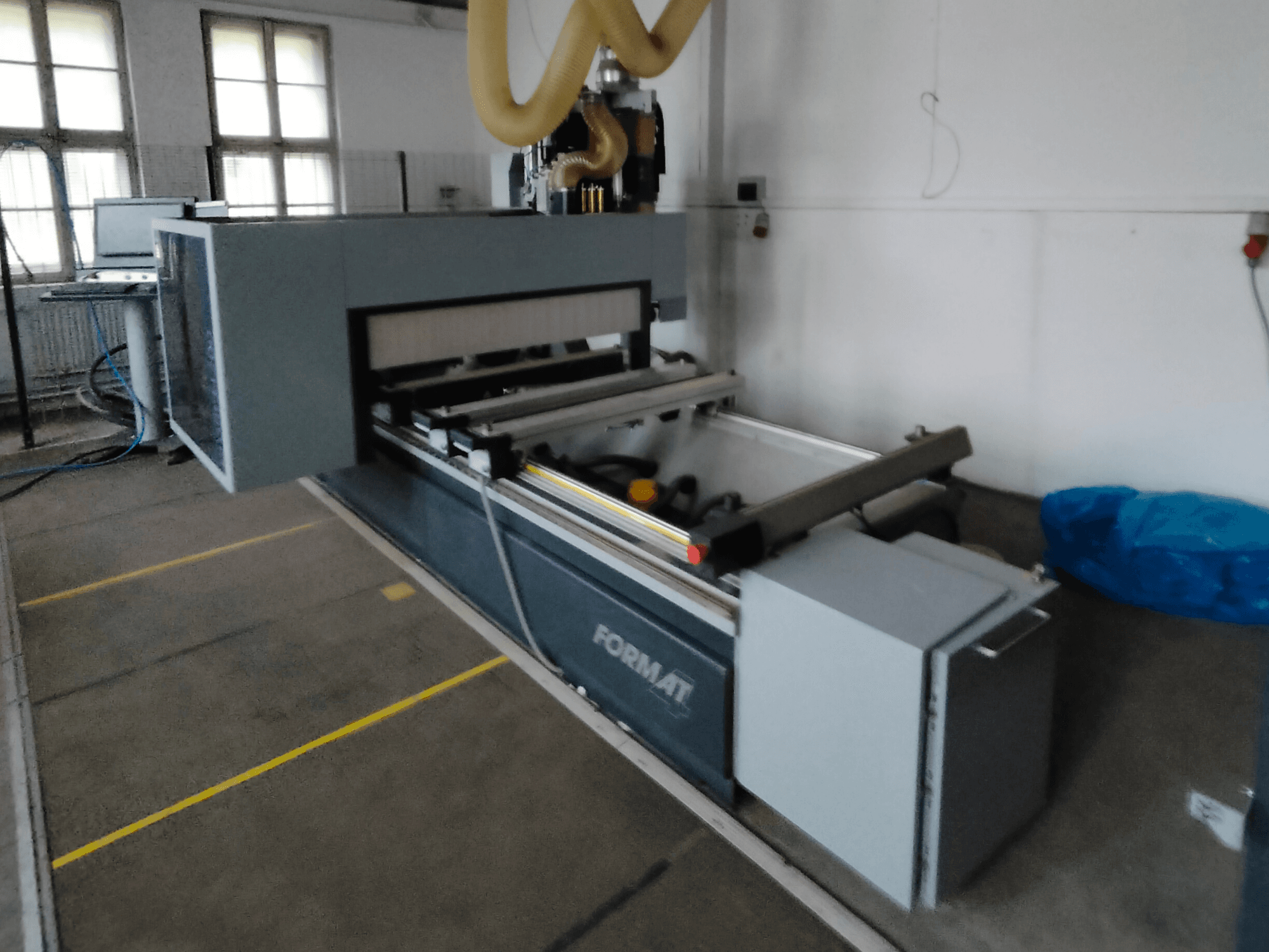 Вид спереду верстата з ЧПК Format із сірим корпусом, з напрямними та видимою панеллю керування.