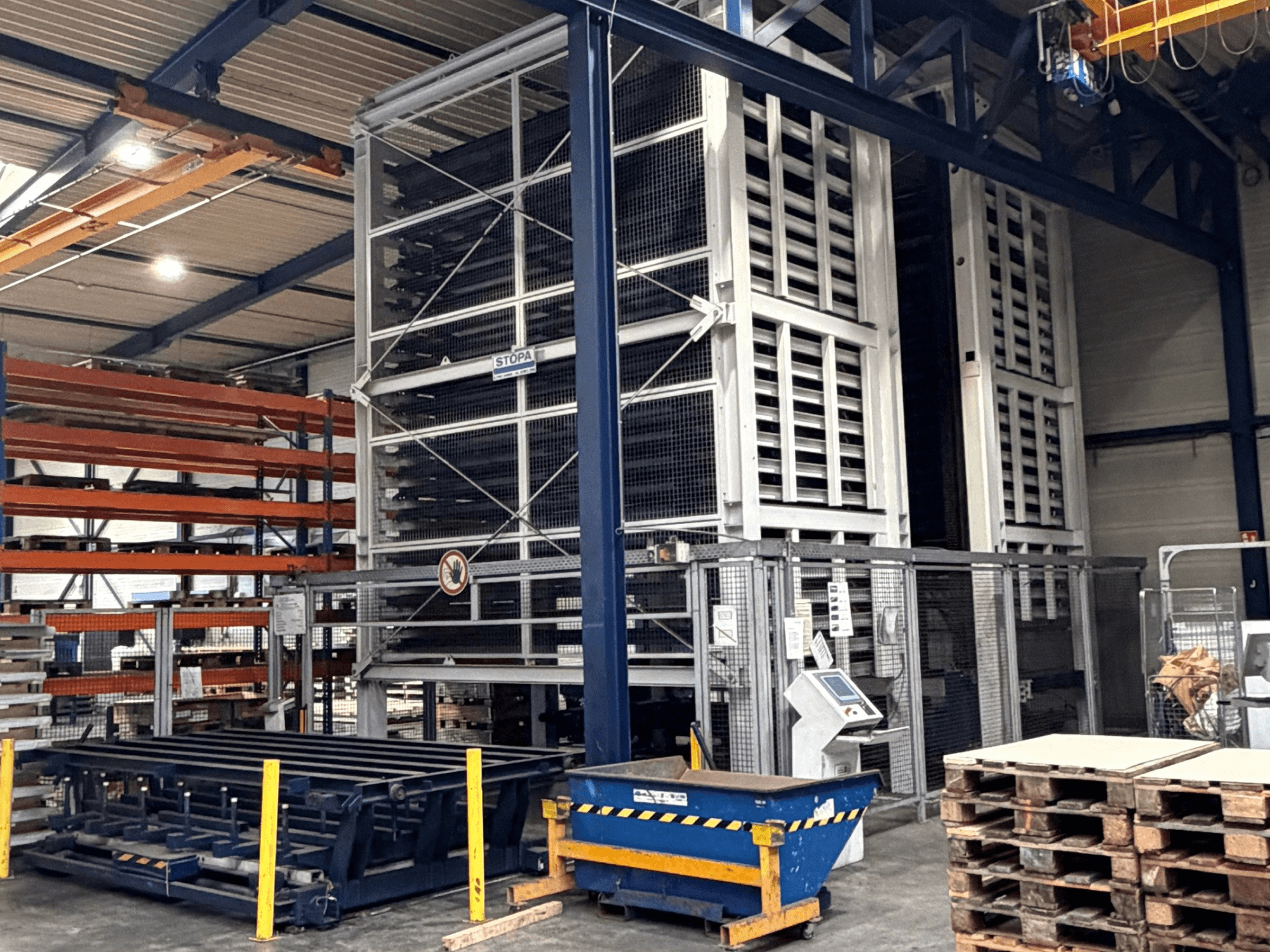 Система автоматизації TRUMPF STOPA 4000x2000 на складі, вид збоку: стелажі та панель управління в зоні зберігання.