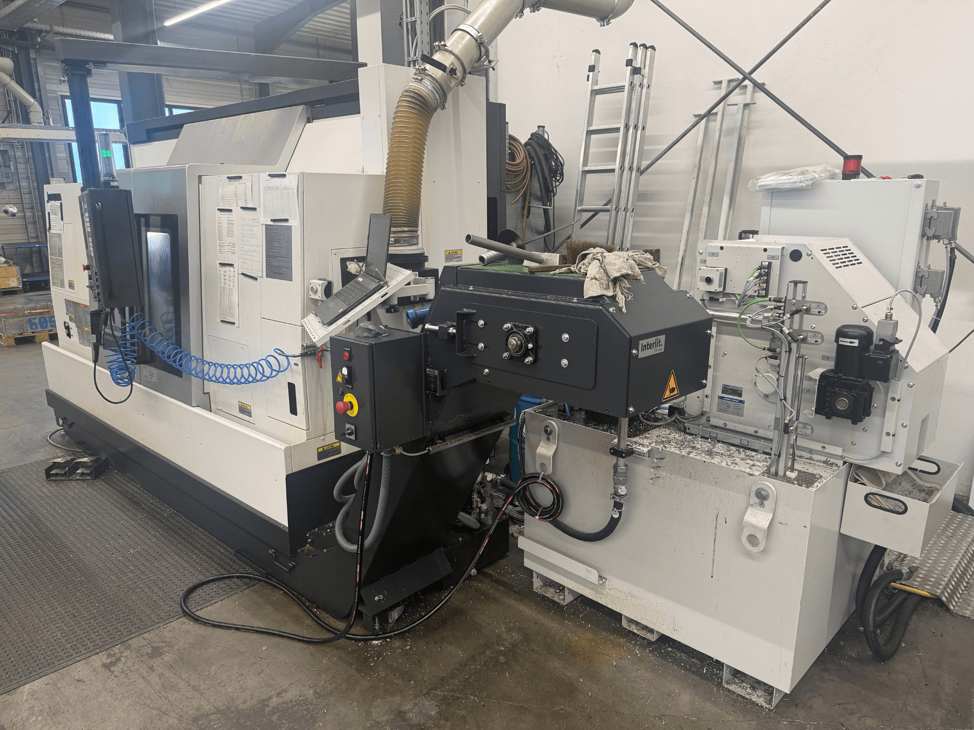 Горизонтальний токарний верстат Okuma LB3000II-MYC 950, вид спереду, демонструє панель керування та систему охолодження.