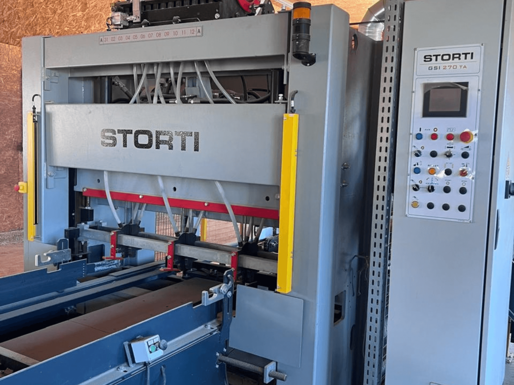 Лінія з виробництва деревини STORTI GSI 170-270 TA9, вид спереду, на якому видно панель управління та механізми гідравлічного преса.
