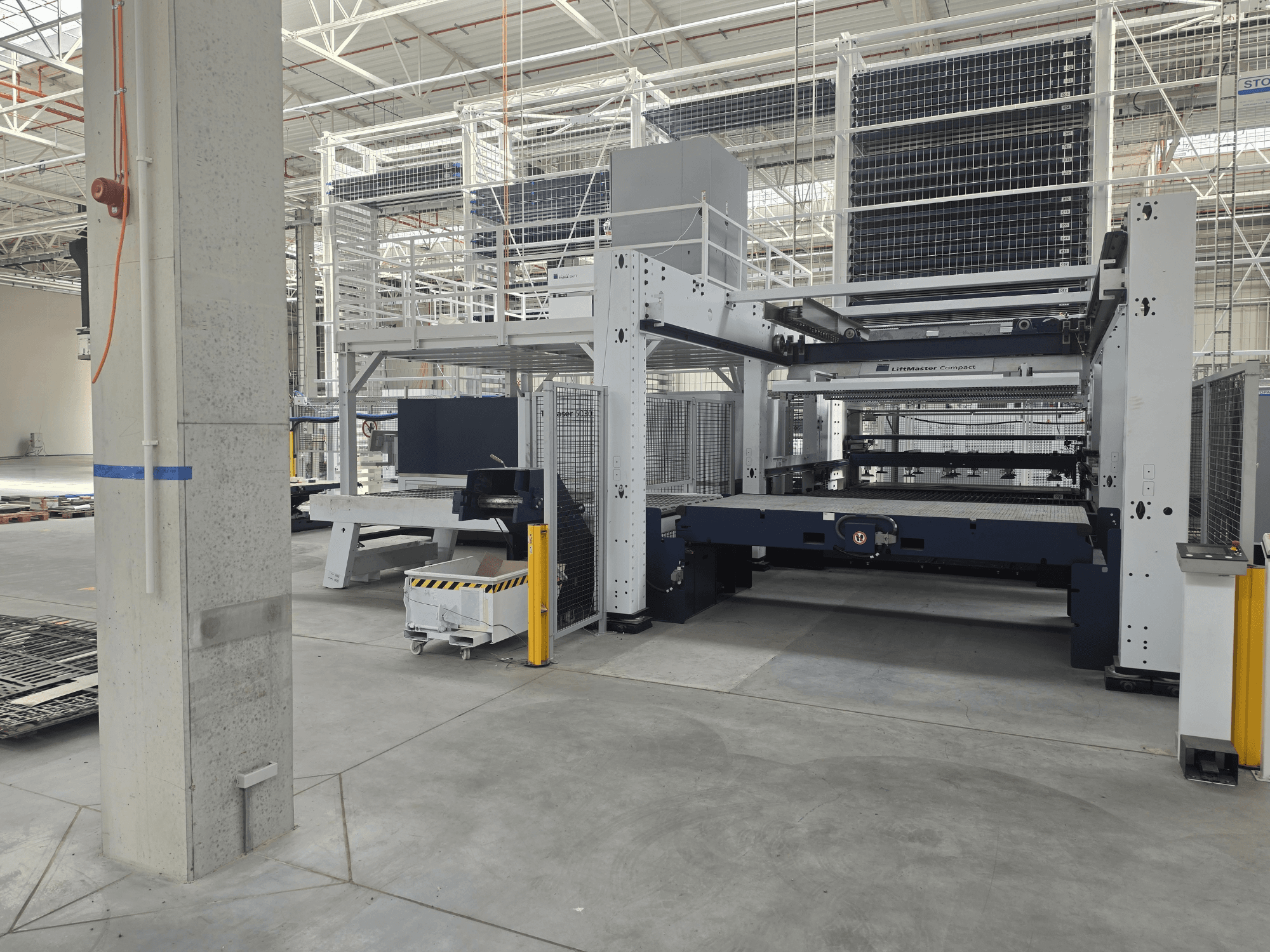 TRUMPF TruLaser 5030 fiber L76 FMC — вид спереду, на якому показано верстат для різання волоконним лазером у просторому промисловому приміщенні.