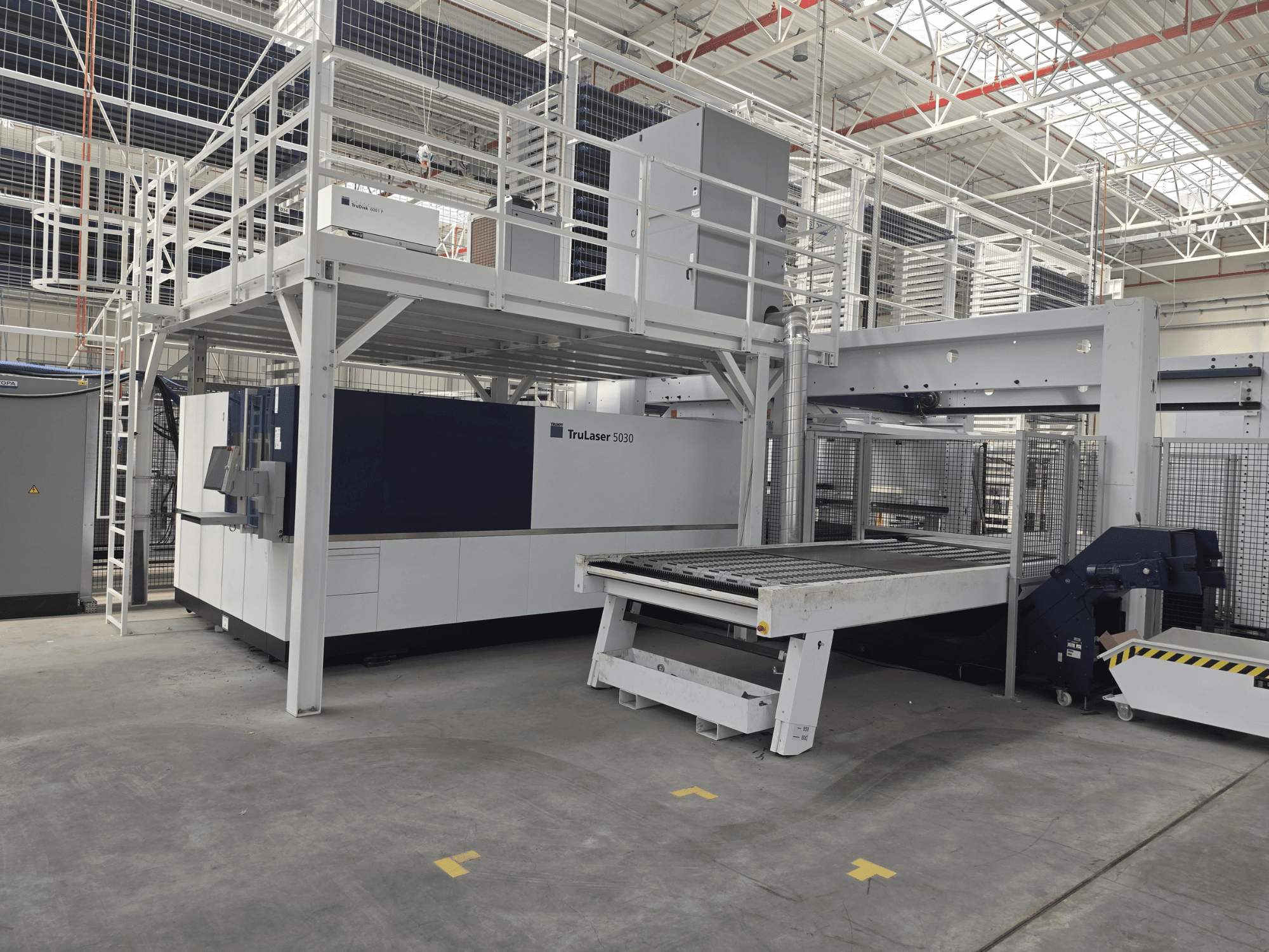 Верстат TRUMPF TruLaser 5030 fiber L76 FMC у цеху, вид спереду, на якому видно зону різання та механізм завантаження/розвантаження.