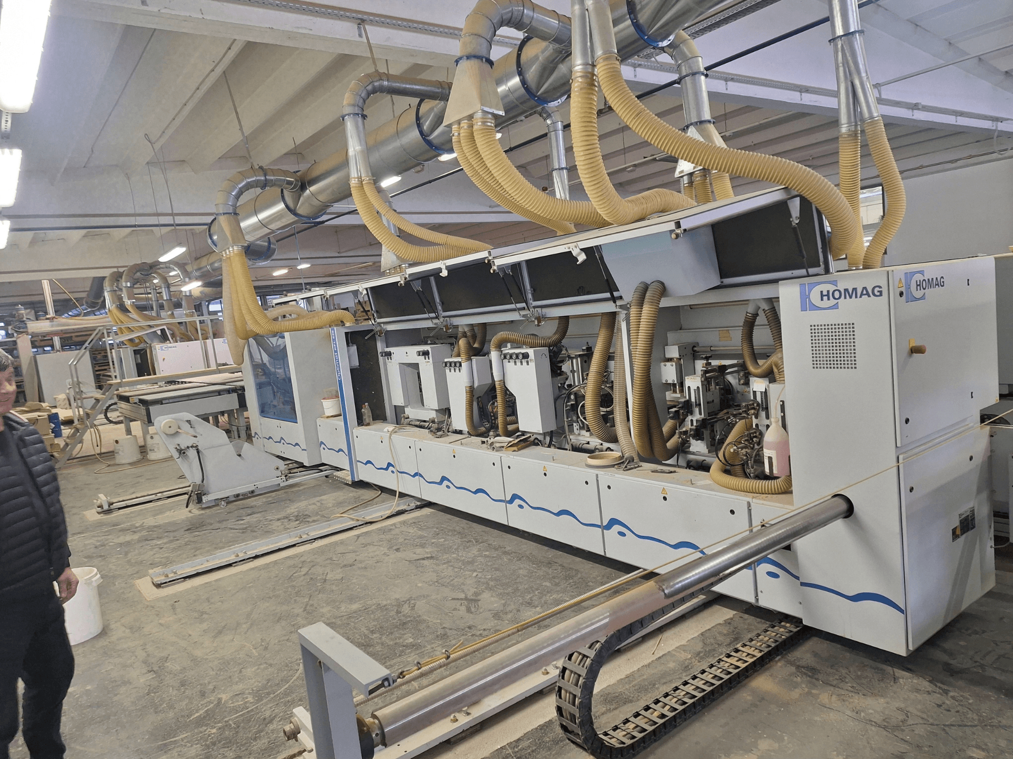 Деревообробний верстат HOMAG у заводських умовах, вид спереду з декількома шпинделями та системою відсмоктування пилу.