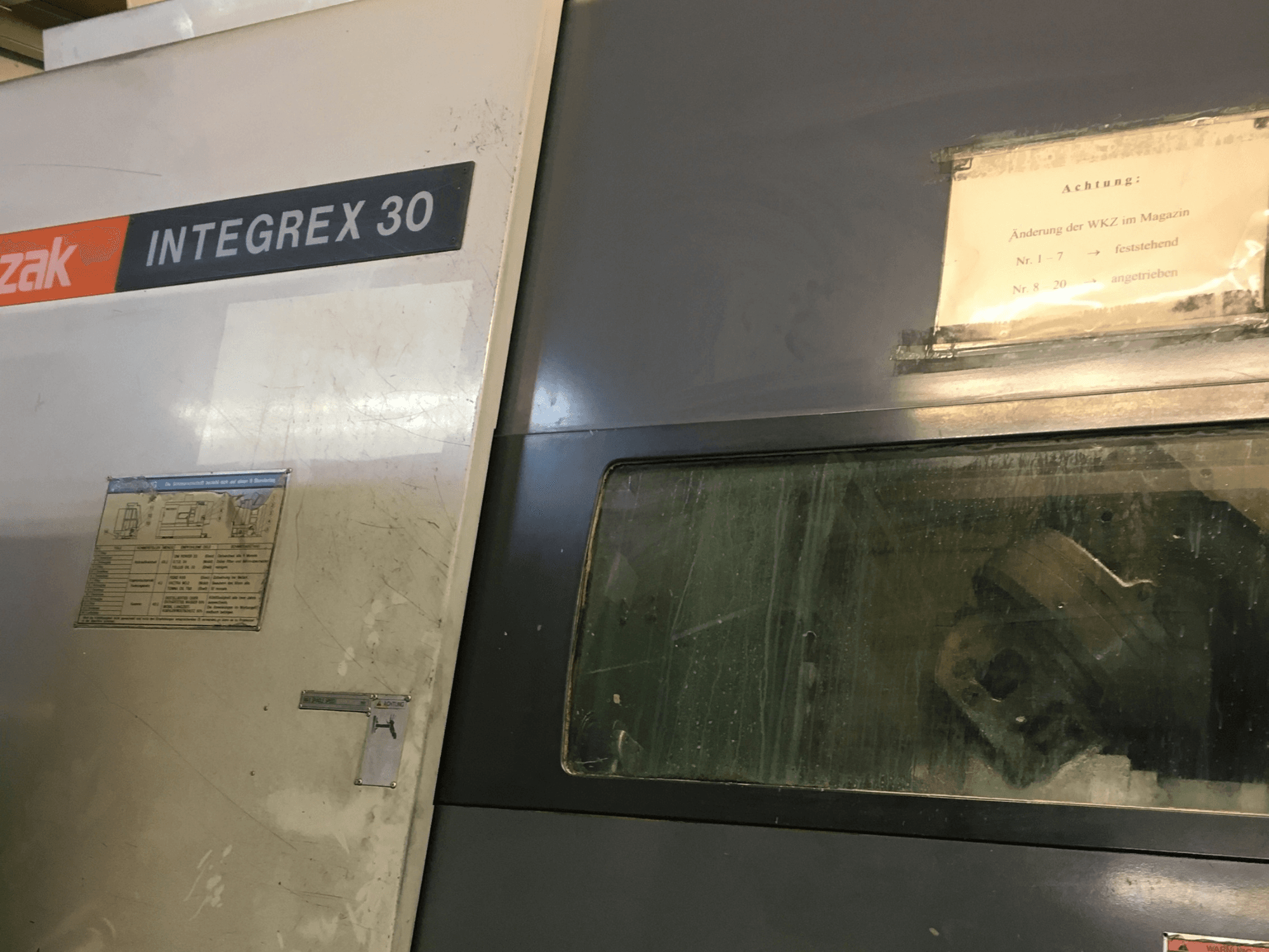 Токарно-фрезерний центр Mazak Integrex 30 Y Universal 1000, вид спереду, на якому видно органи управління та інструмент, що знаходиться всередині вікна.