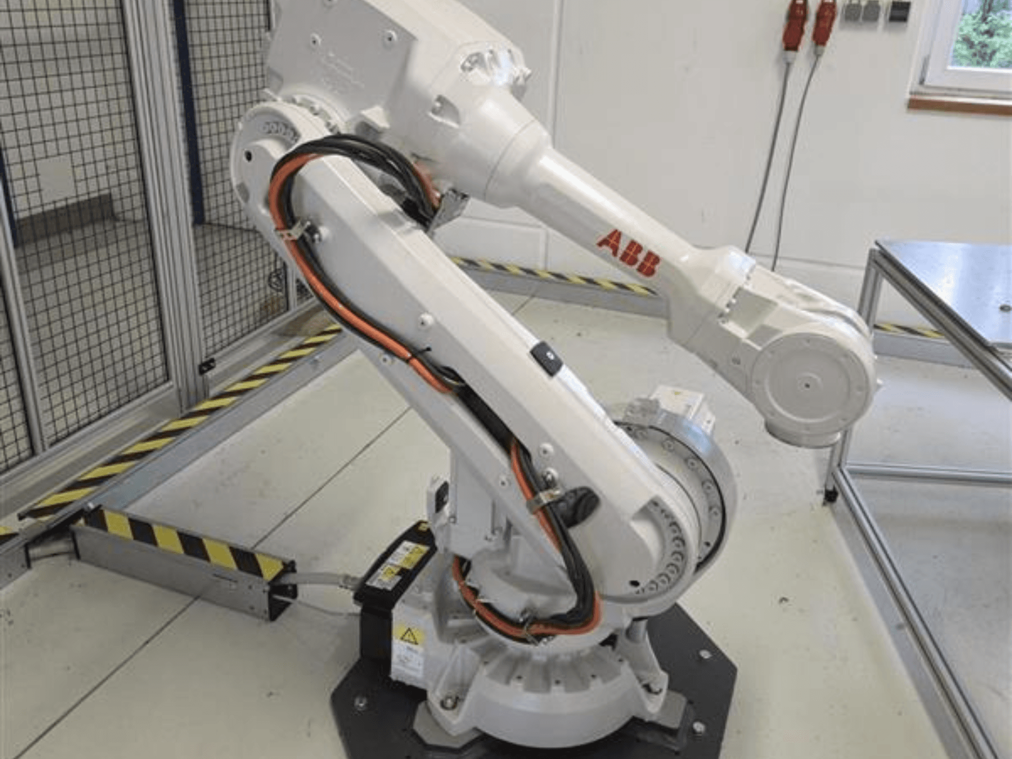 Роботизована рука ABB IRB 4600-45/2.05 у профілі, що демонструє її шарнірну конструкцію та кабелі, підключені до основи.