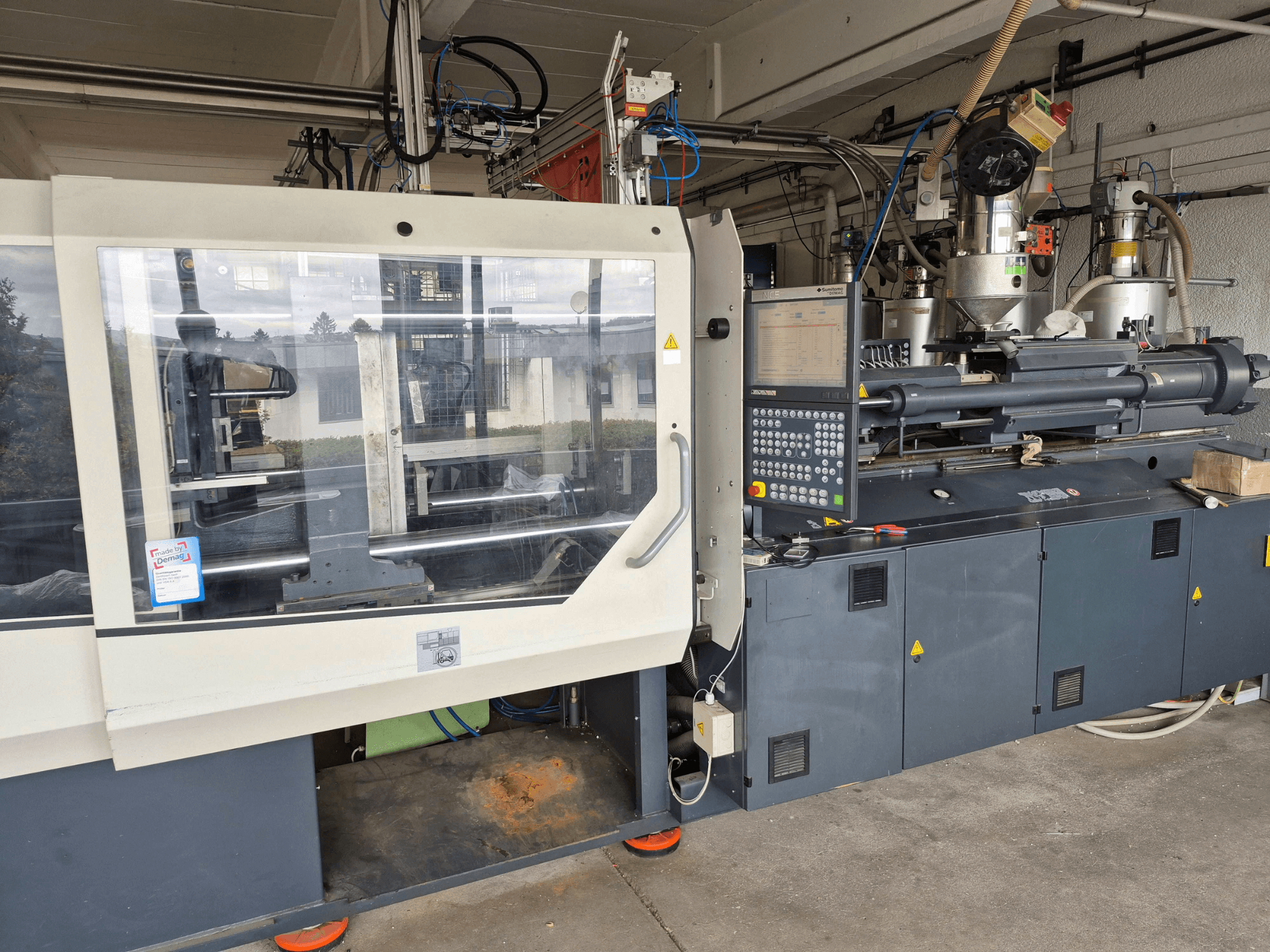 Гідравлічна машина для лиття під тиском, SUMITOMO SHI DEMAG Systec 210/580-1450, вид спереду з панеллю керування та видимими компонентами.