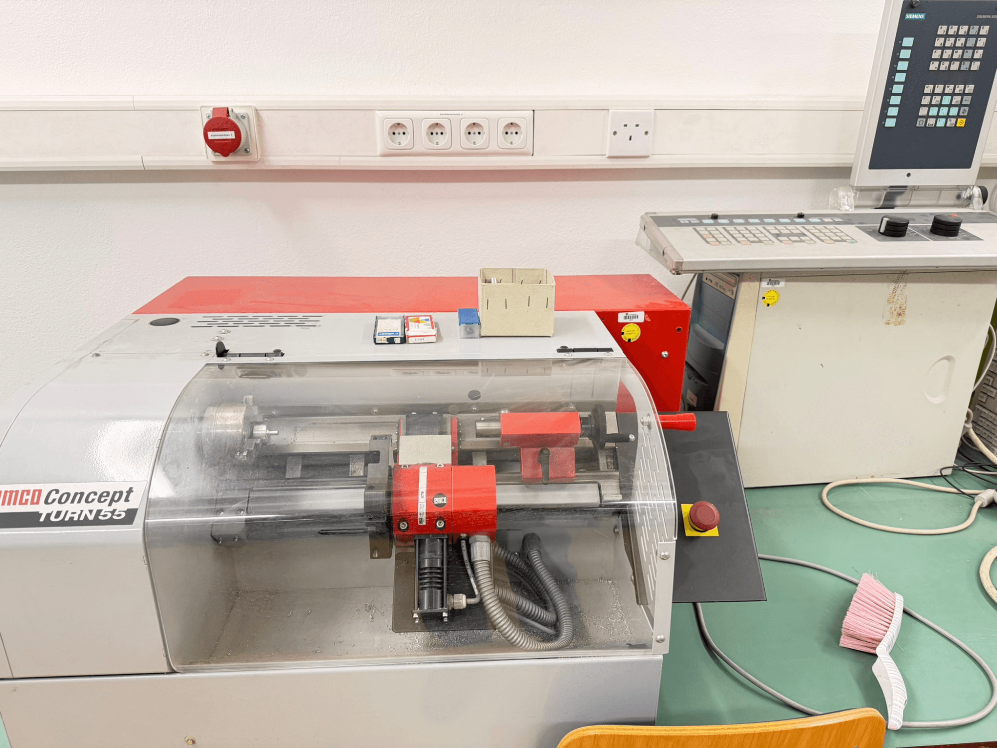 Горизонтальний токарний верстат EMCO Concept Turn 55 з червоно-сірим зовнішнім виглядом, вид спереду з елементами керування та робочою зоною.