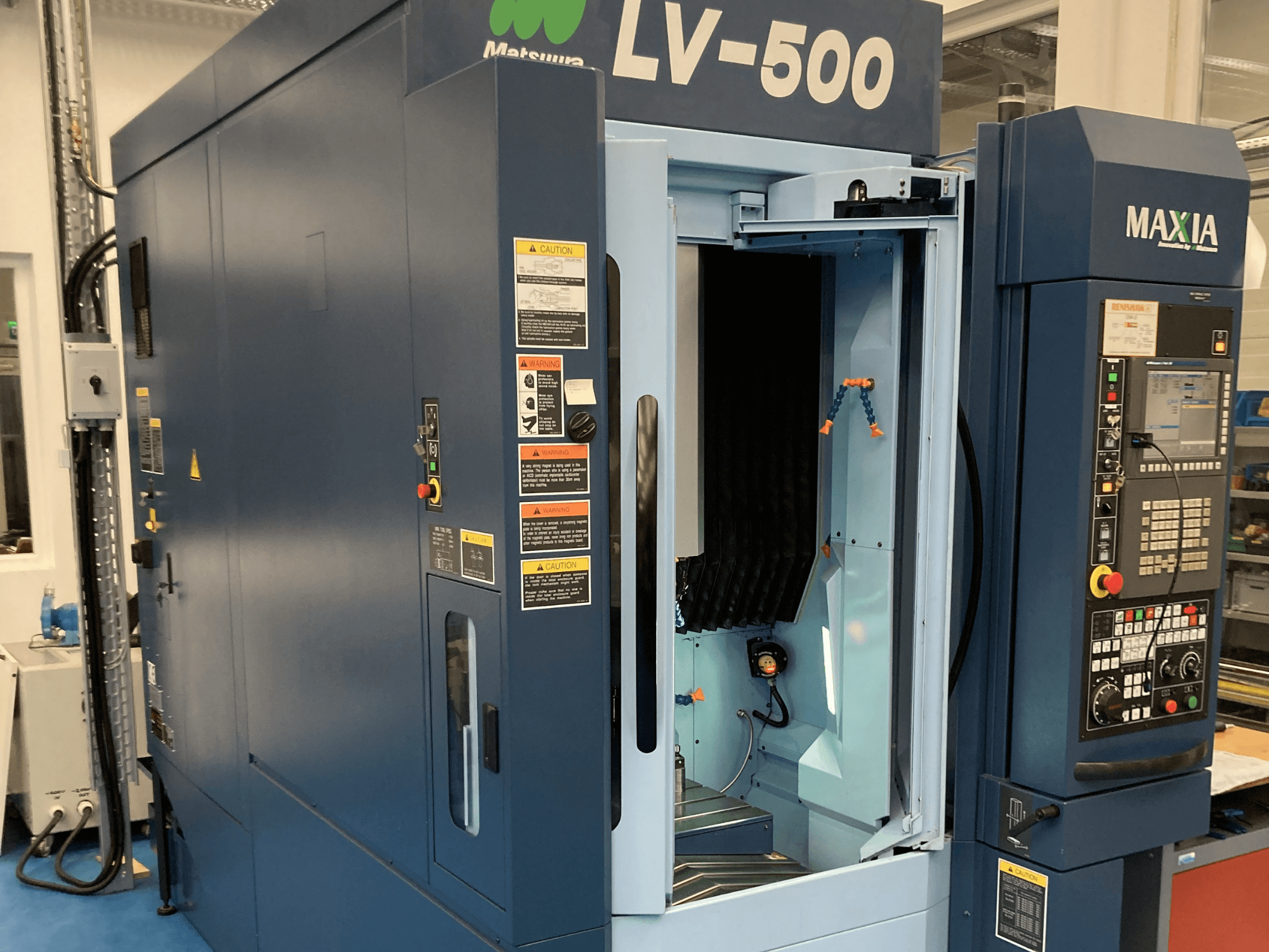Вертикальний обробний центр Matsuura LV-500 показаний спереду, з відкритими дверцятами та панеллю керування з кнопками.
