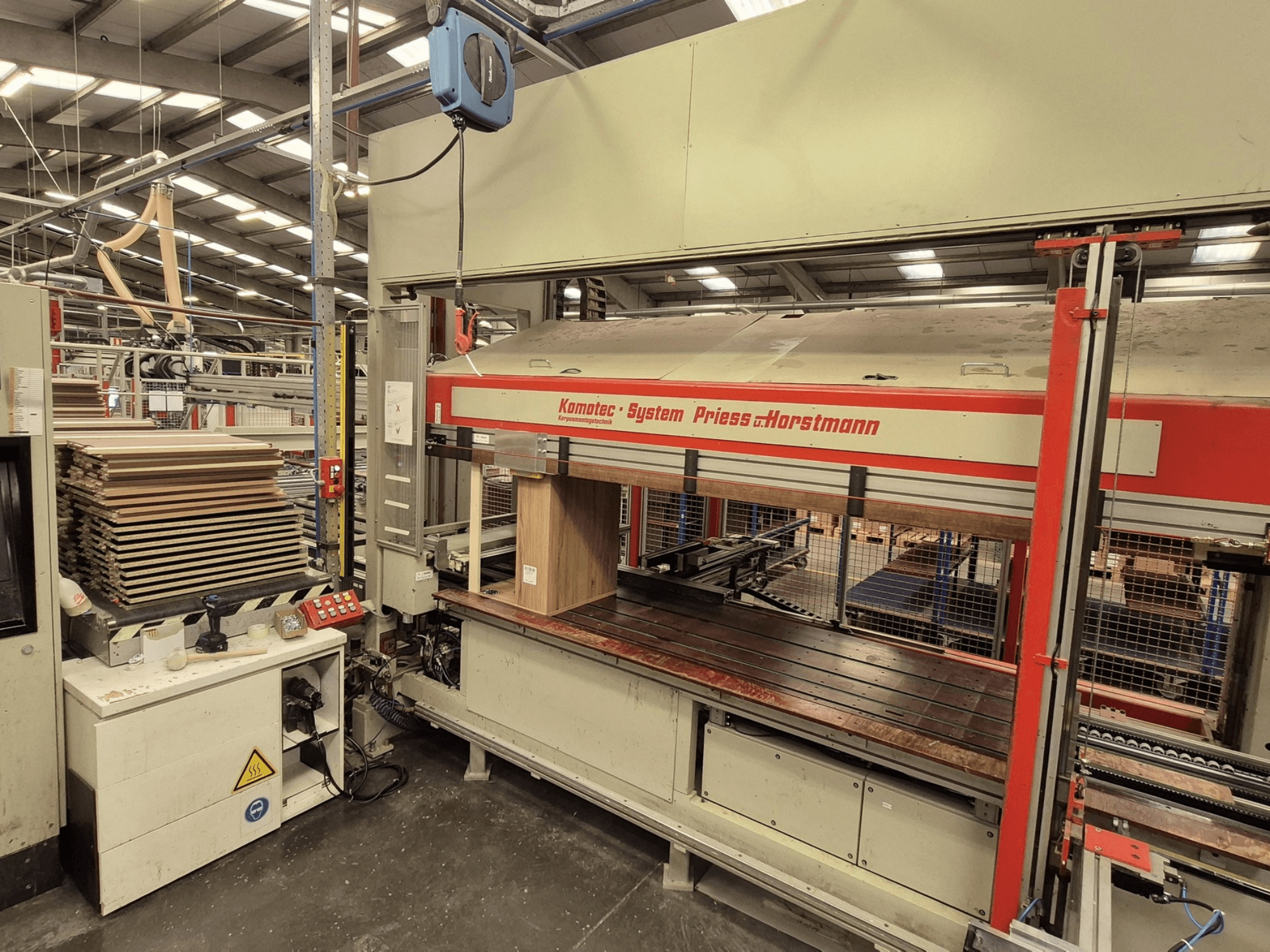 Шпоновий прес KP-5-CNC від PREISS U HORTSTMANN, вигляд спереду, демонструє укладені листи шпону та панель керування.
