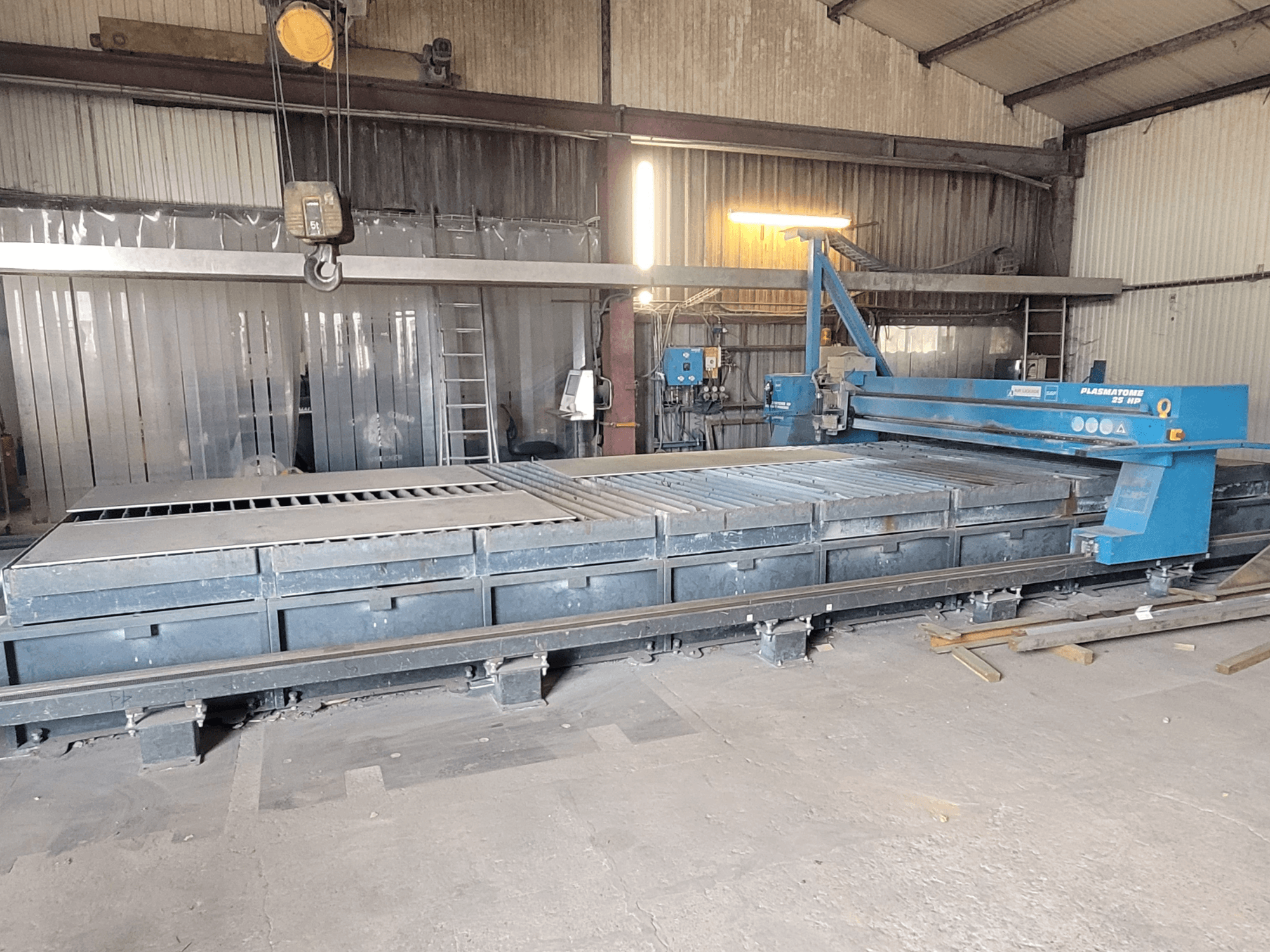 Машина для плазмового різання SAF Plasmatone 25 к.с., вид збоку, демонструє робочу поверхню та робочі компоненти в промислових умовах.