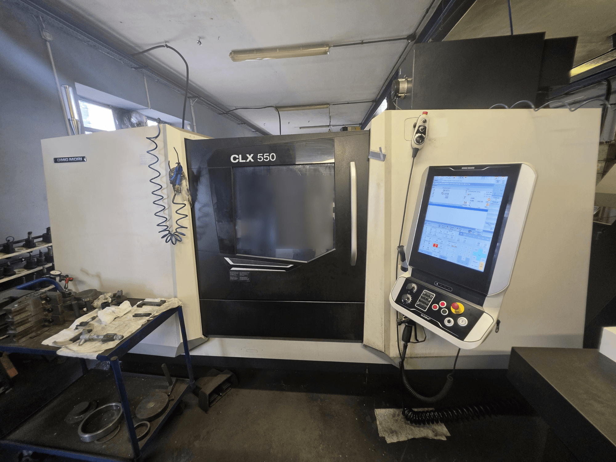 Горизонтальний токарний верстат DMG MORI CLX 550 V3, вид спереду, на якому видно панель керування та робочу зону з інструментами.
