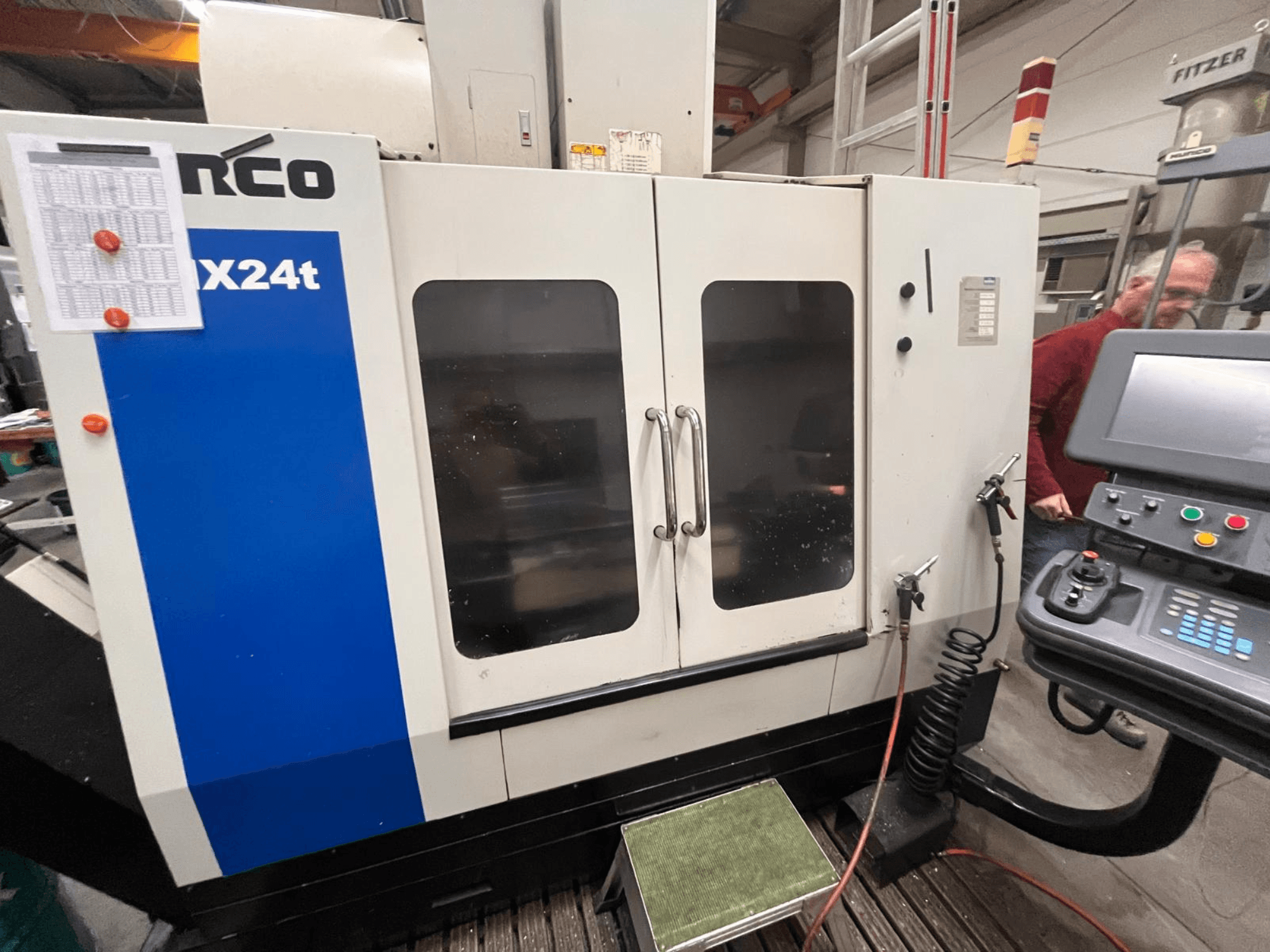 Вертикальний обробний центр Hurco, модель VX24t, показаний спереду з панеллю керування та прозорими дверима.