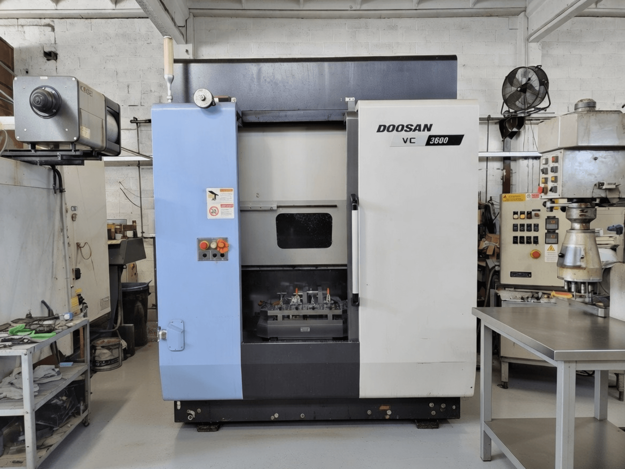 Вертикальний обробний центр DOOSAN VC 3600 спереду, з панеллю керування та відкритими дверцятами, що відкривають робочий простір.
