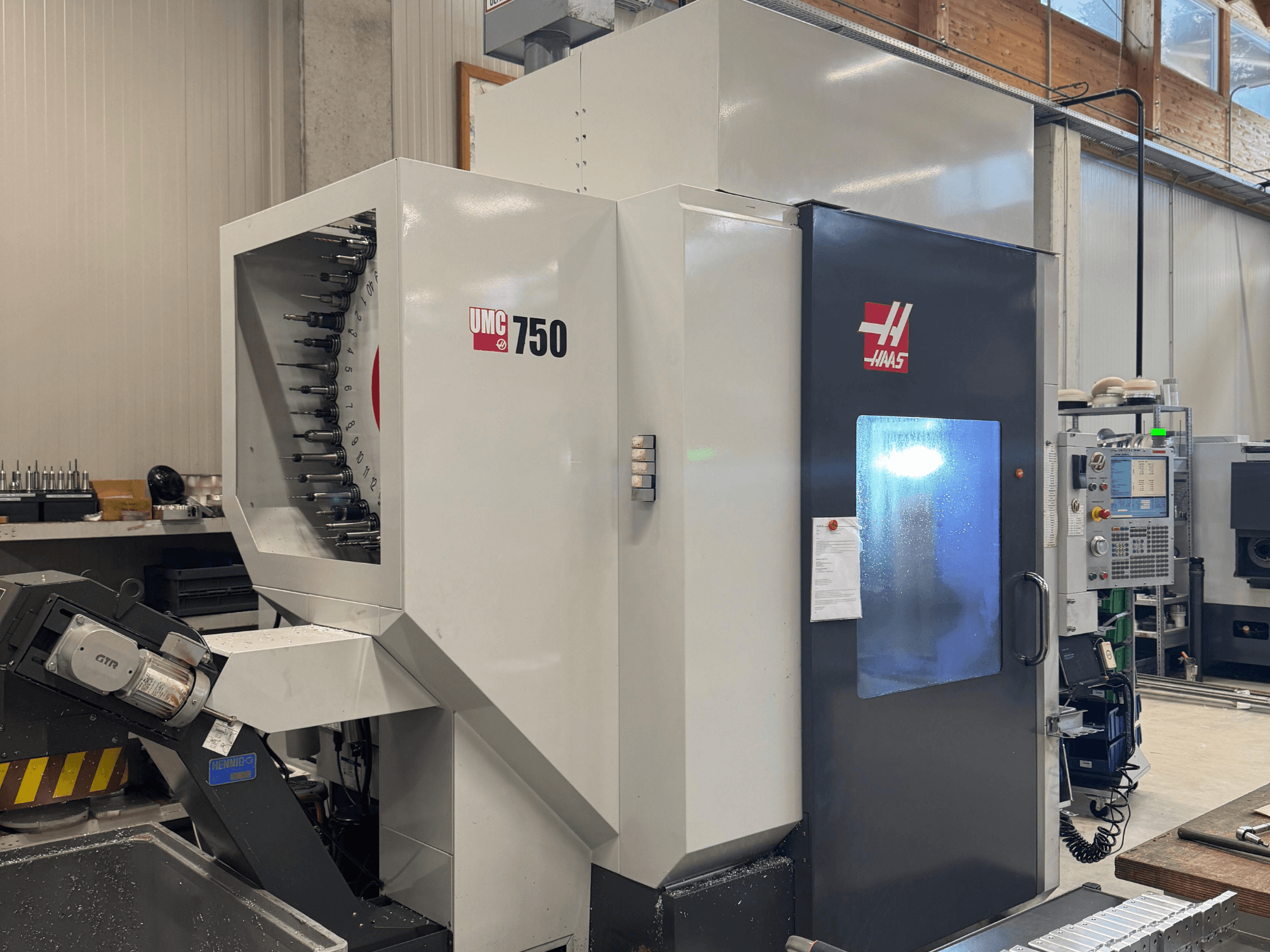 Обробний центр Haas UMC 750, вигляд спереду, демонстрація тримача інструменту та панелі керування в умовах майстерні.