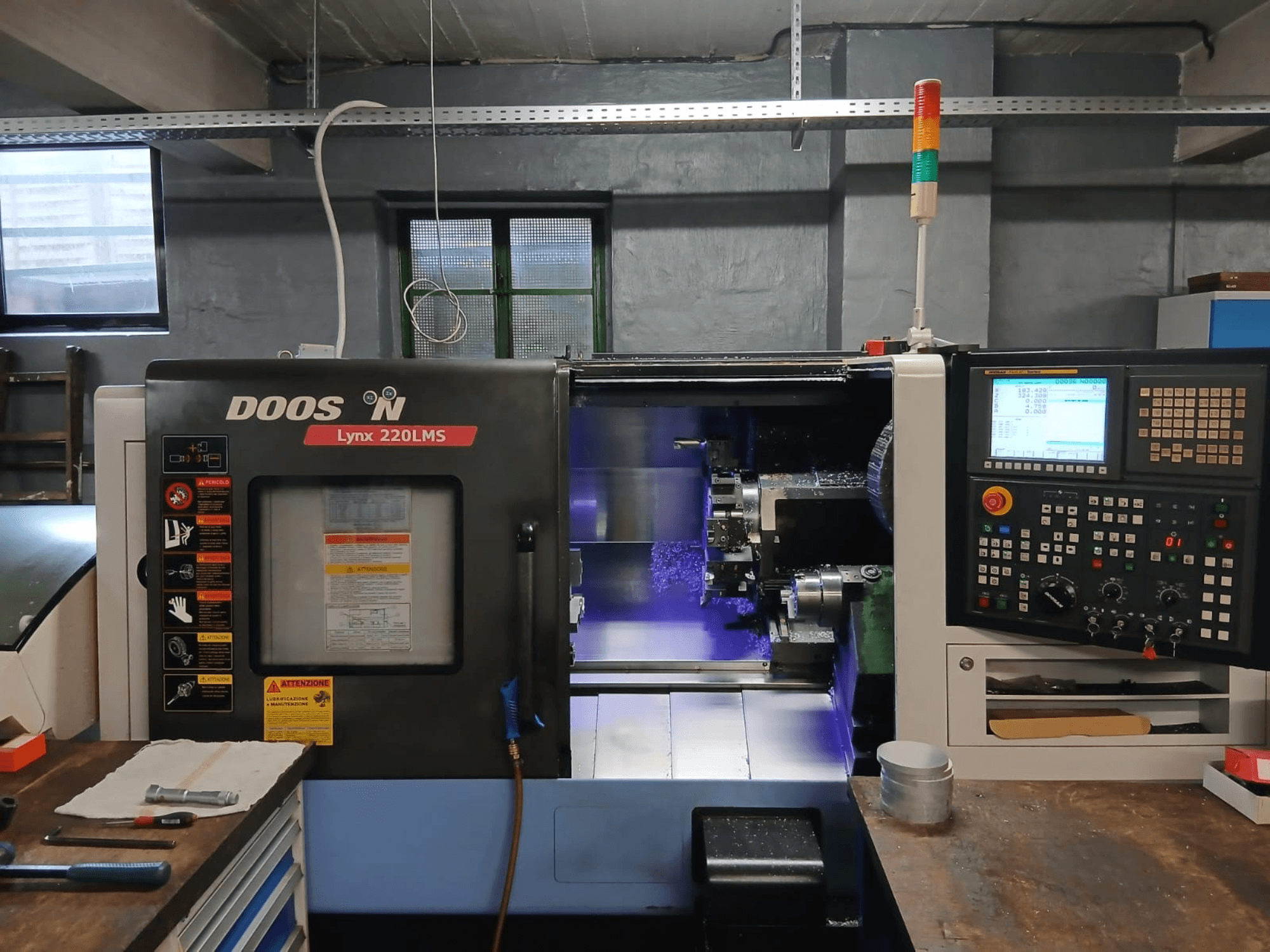 Горизонтальний токарний верстат DOOSAN Lynx 220 LMS, вид спереду, на якому видно панель управління та зону обробки.