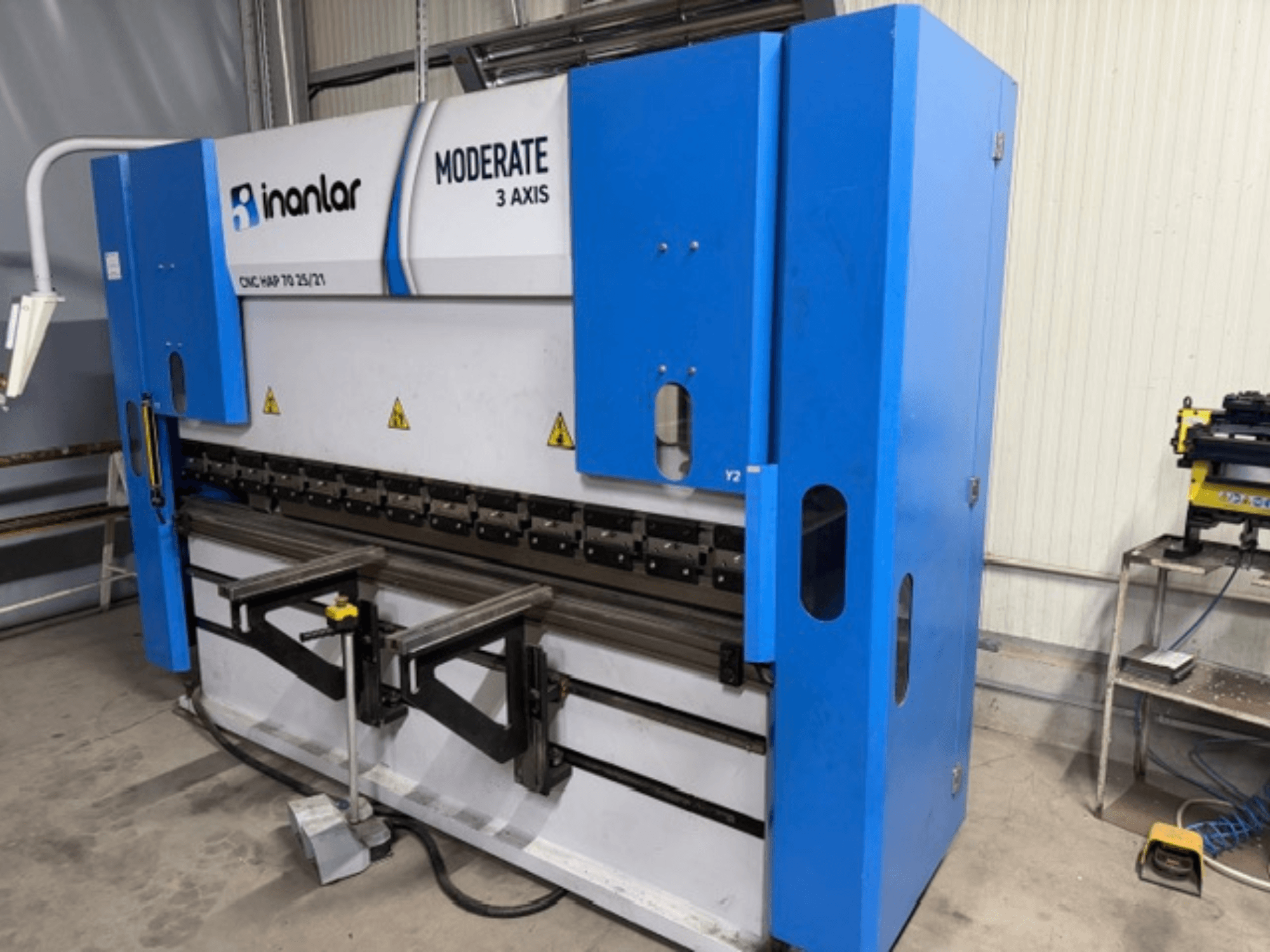 3-координатний верстат з ЧПК Inanlar Moderate синього кольору, вид спереду, з важелями керування та етикетками безпеки, видимими на корпусі.