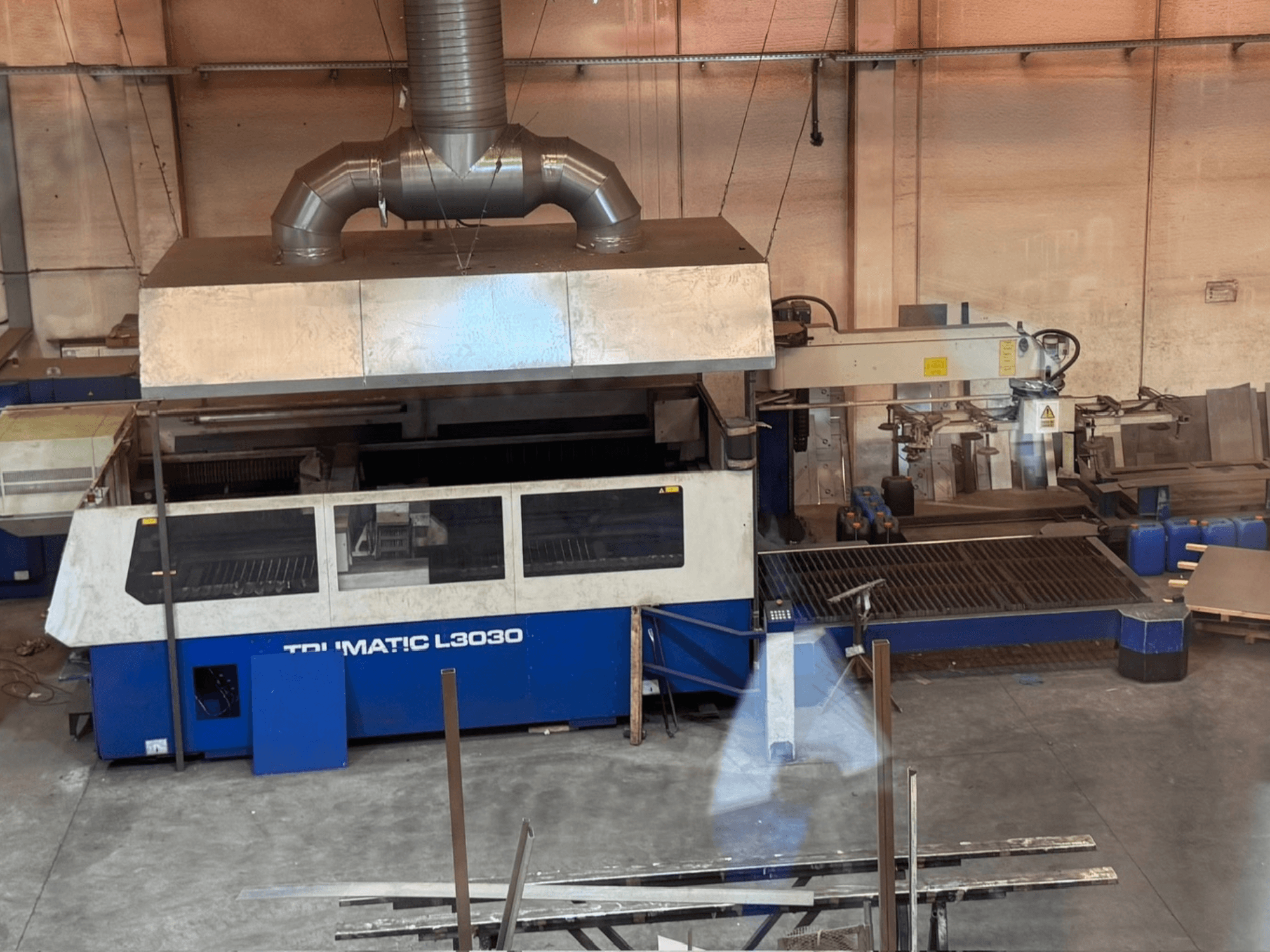 Лазерний різальний верстат CO2 TRUMPF TRUMATIC L3030 у цеху, вид спереду, на якому видно панель управління та робочий стіл.