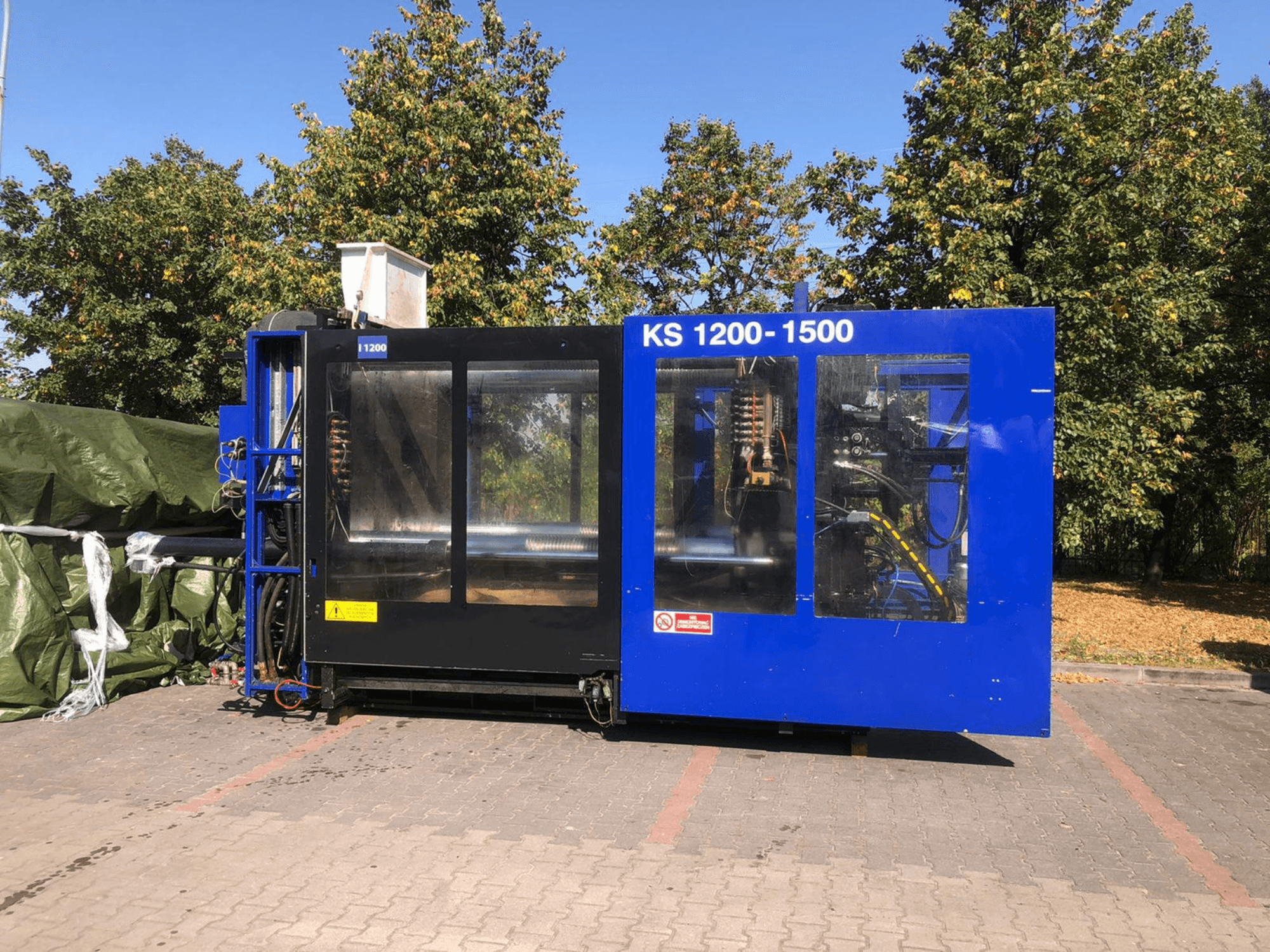 Гідравлічний термопластавтомат ITALTECH KS 1200 8300 ES, вид збоку, демонструє елементи керування та деталі машини в умовах парку.