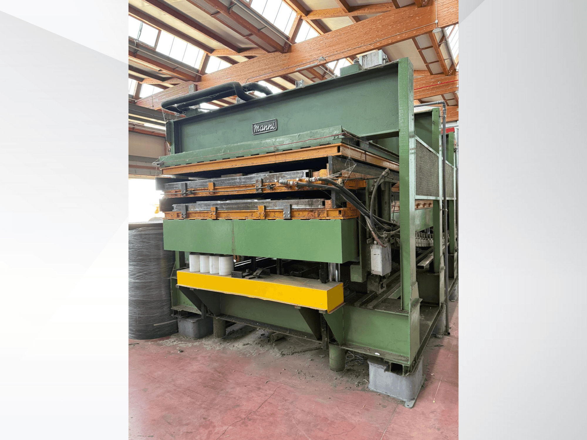 Гідравлічний прес Manni, вид збоку, із зеленим металевим корпусом, жовтою основою та декількома гідравлічними лініями.