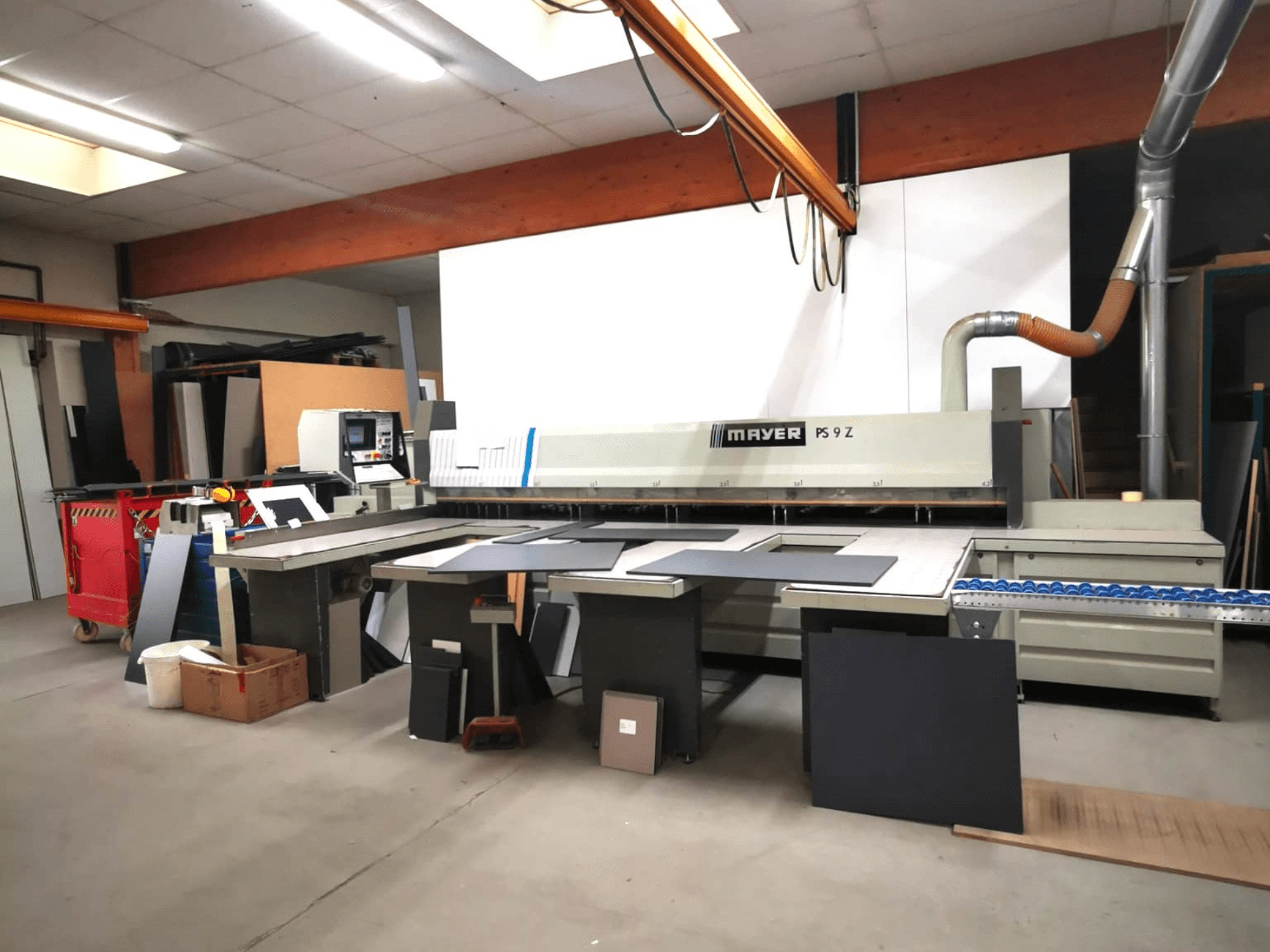 Розкрійний верстат MAYER PS9 Z в майстерні, вид спереду, видно різні матеріали та конвеєрну систему.