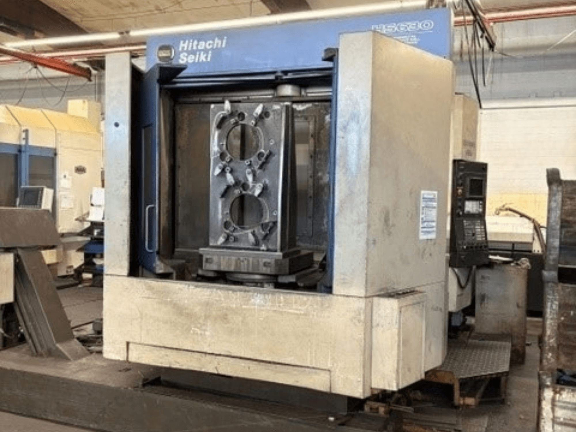 Горизонтальний обробний центр Hitachi Seiki HS630, вид спереду, на якому видно заготовку та панель управління.