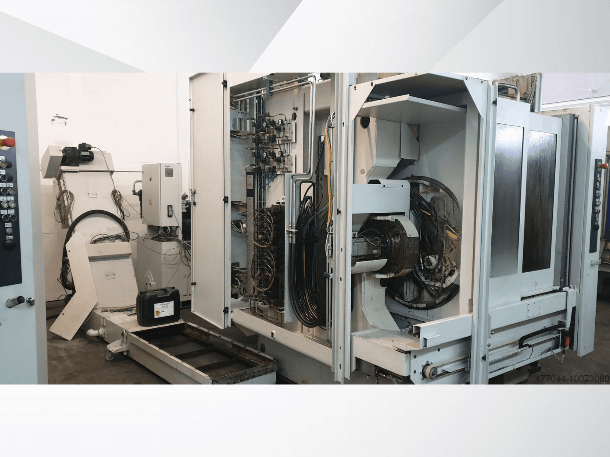 Промислове обладнання з відкритою проводкою, панеллю керування та механічними компонентами; вигляд збоку складної машини.