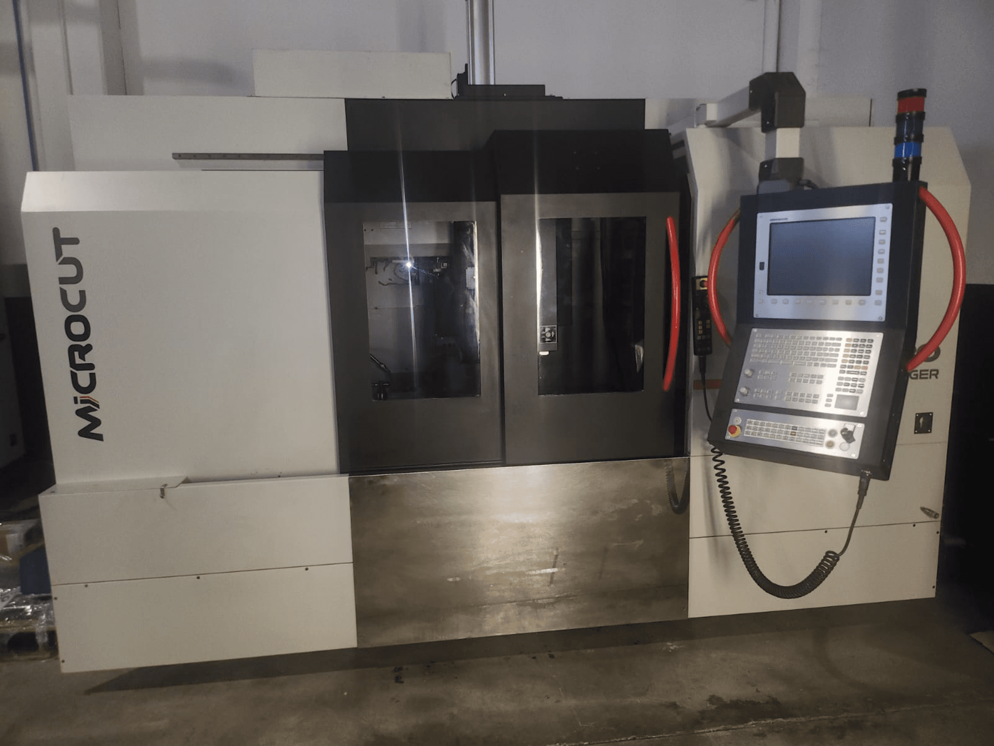 Мікрорізальний верстат з ЧПУ, вид спереду; має панель керування, подвійні вікна, промисловий дизайн та металеве покриття.