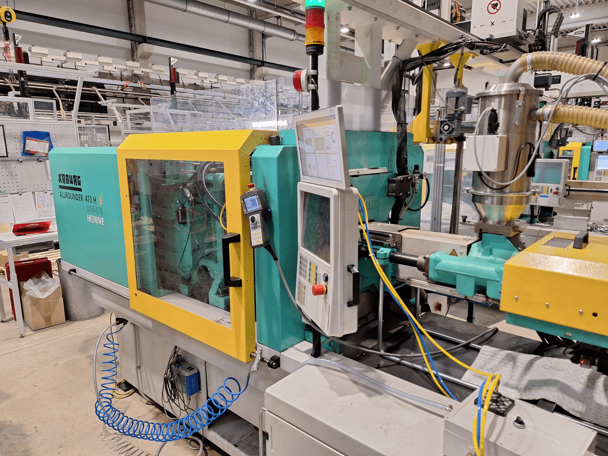 Гідравлічна машина для лиття під тиском Arburg 470 H 1000-170, вид збоку, що демонструє панель управління і систему подачі.