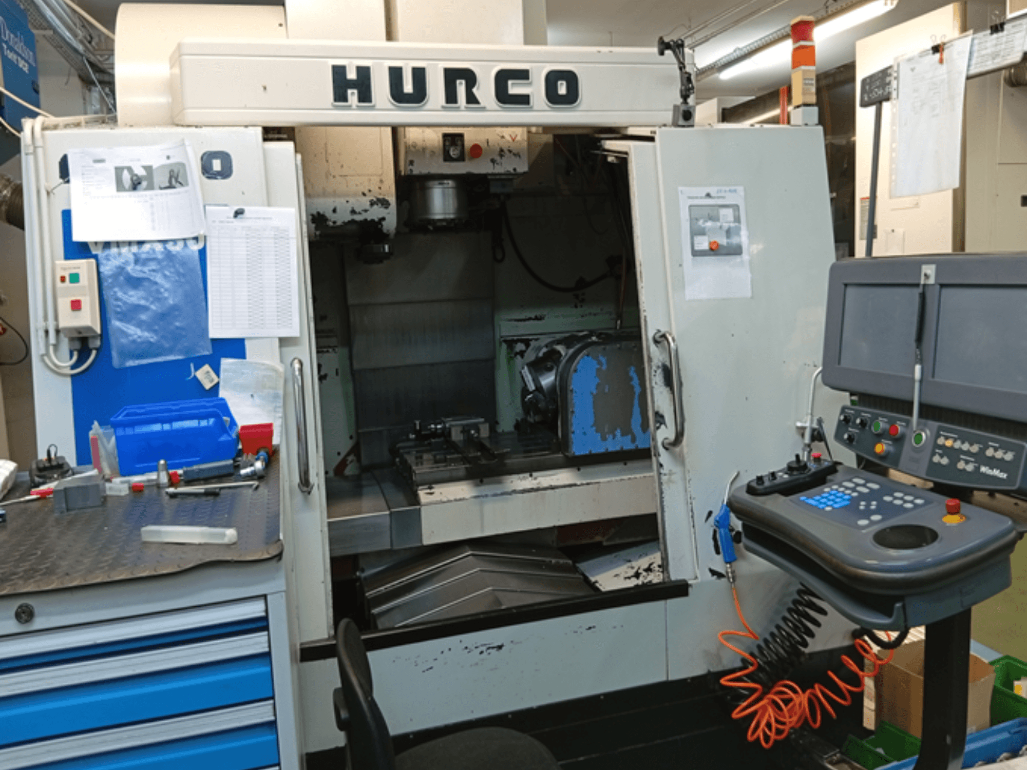 Вертикальний обробний центр Hurco VMX 30T, вид спереду, з панеллю керування, робочим простором і частково відкритими дверцятами.