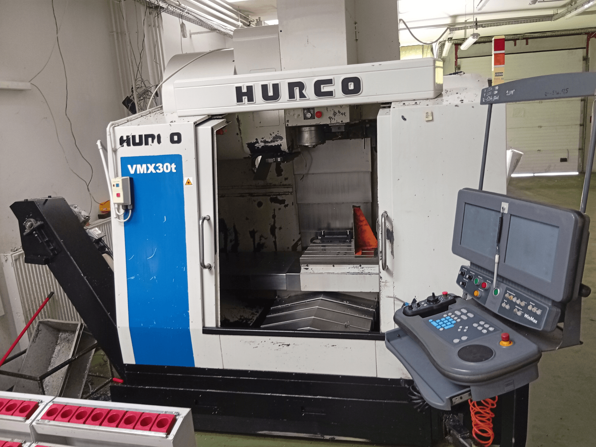 Вертикальний обробний центр Hurco VMX 30T, вид спереду, на якому видно панель управління та зону шпинделя з робочим столом.