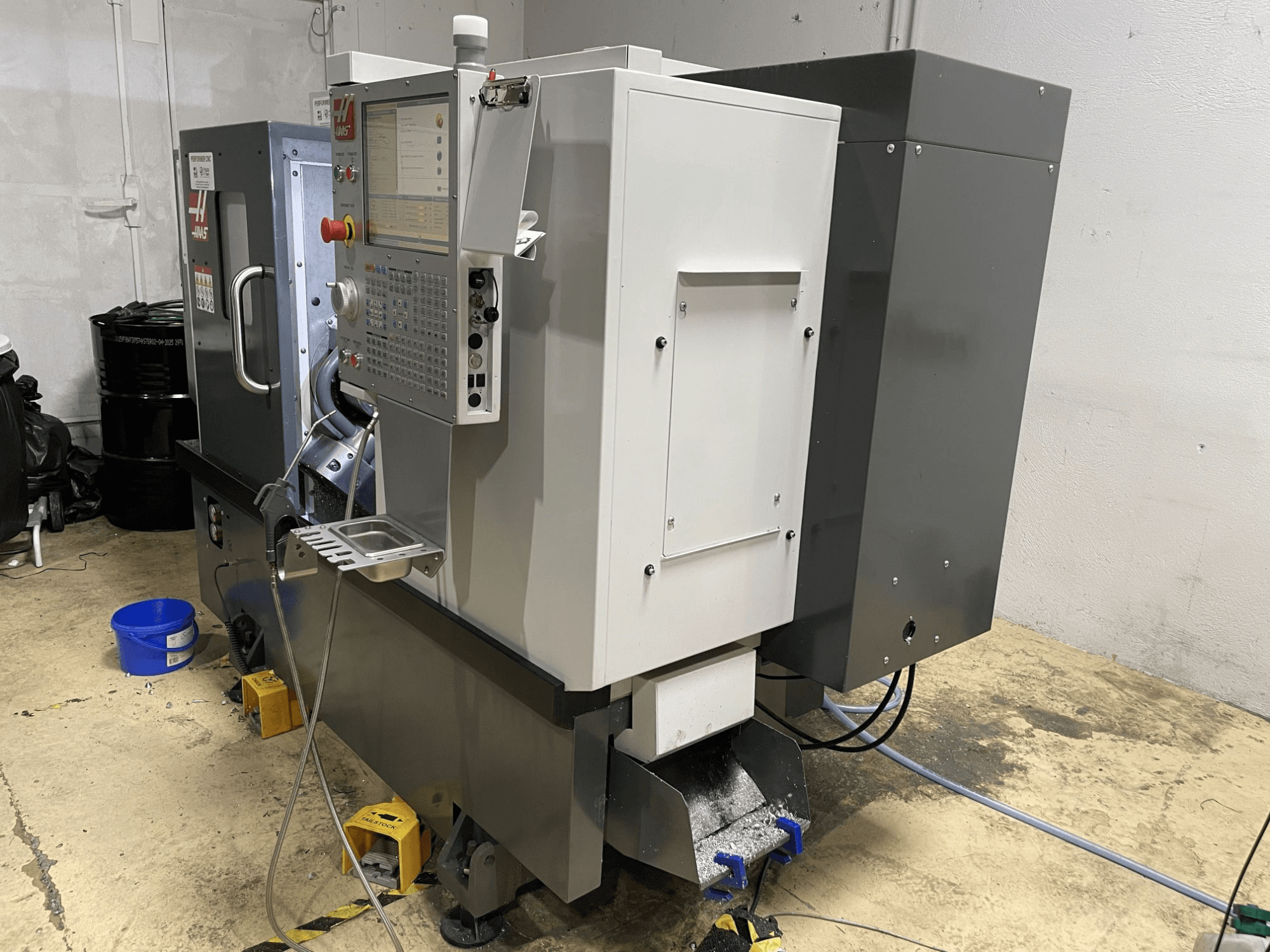 Горизонтальний токарний верстат HAAS ST-15Y у цеху, оснащений панеллю керування та відрізняється міцною промисловою конструкцією.