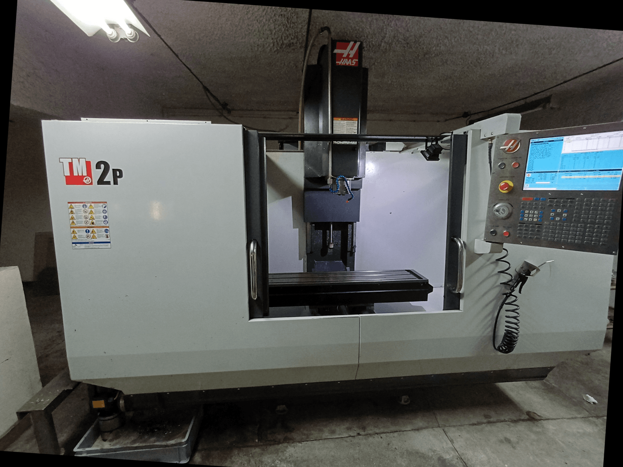 Вертикальний обробний центр HAAS TM-2P, вид спереду, з панеллю керування, шпиндельною головкою та станиною верстата.