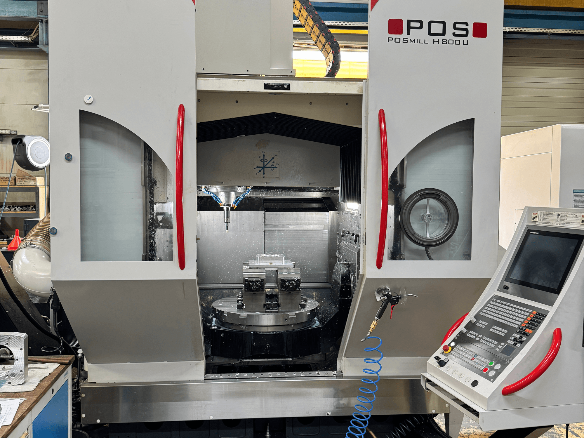 Вертикальний обробний центр POSmill H 800 U, вид спереду, на якому видно внутрішні компоненти, систему охолодження та панель керування.