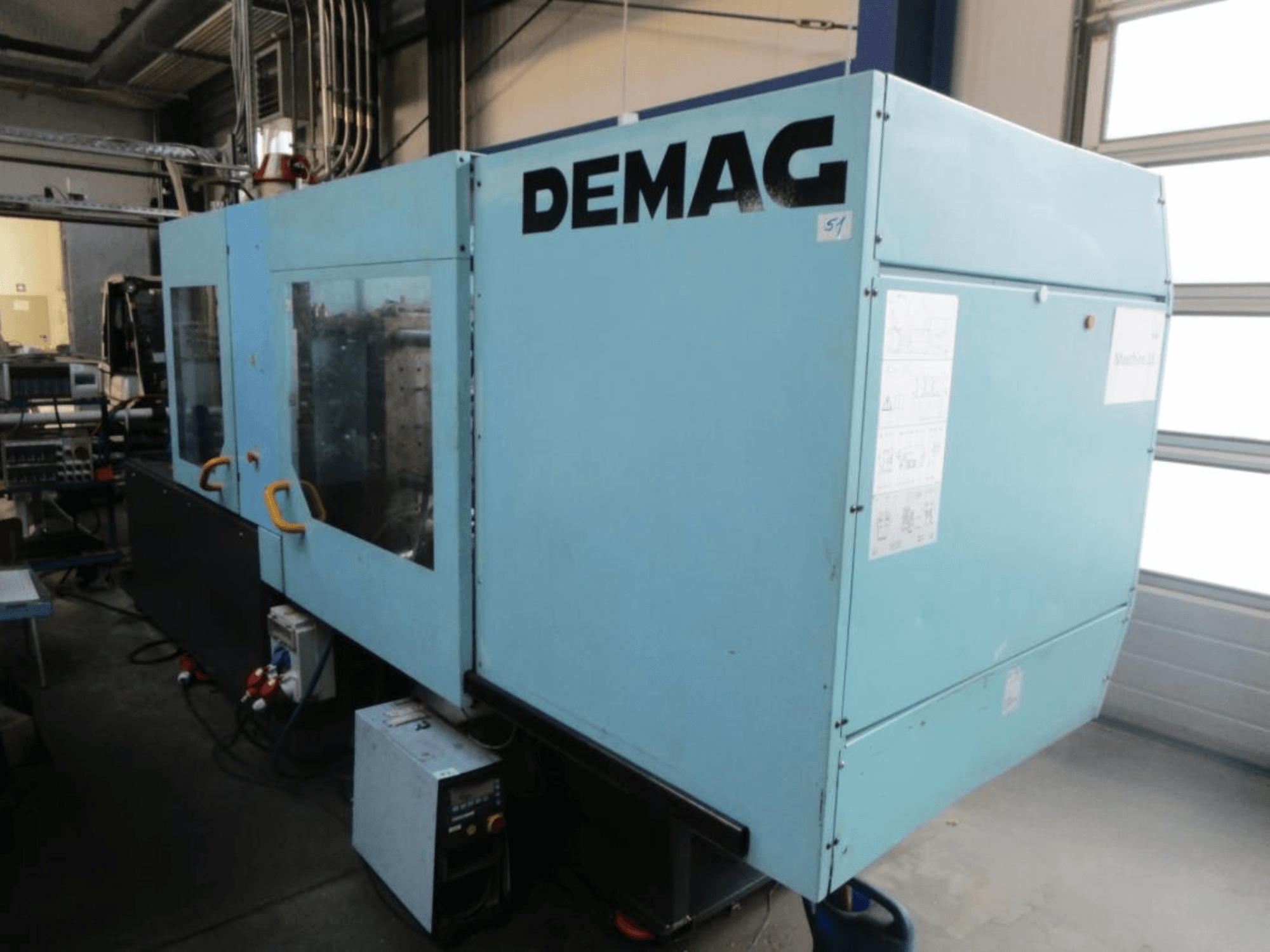 Вигляд спереду гідравлічної машини для лиття під тиском DEMAG Ergotech 150-610 Viva з панеллю керування та ручками, що добре видно.