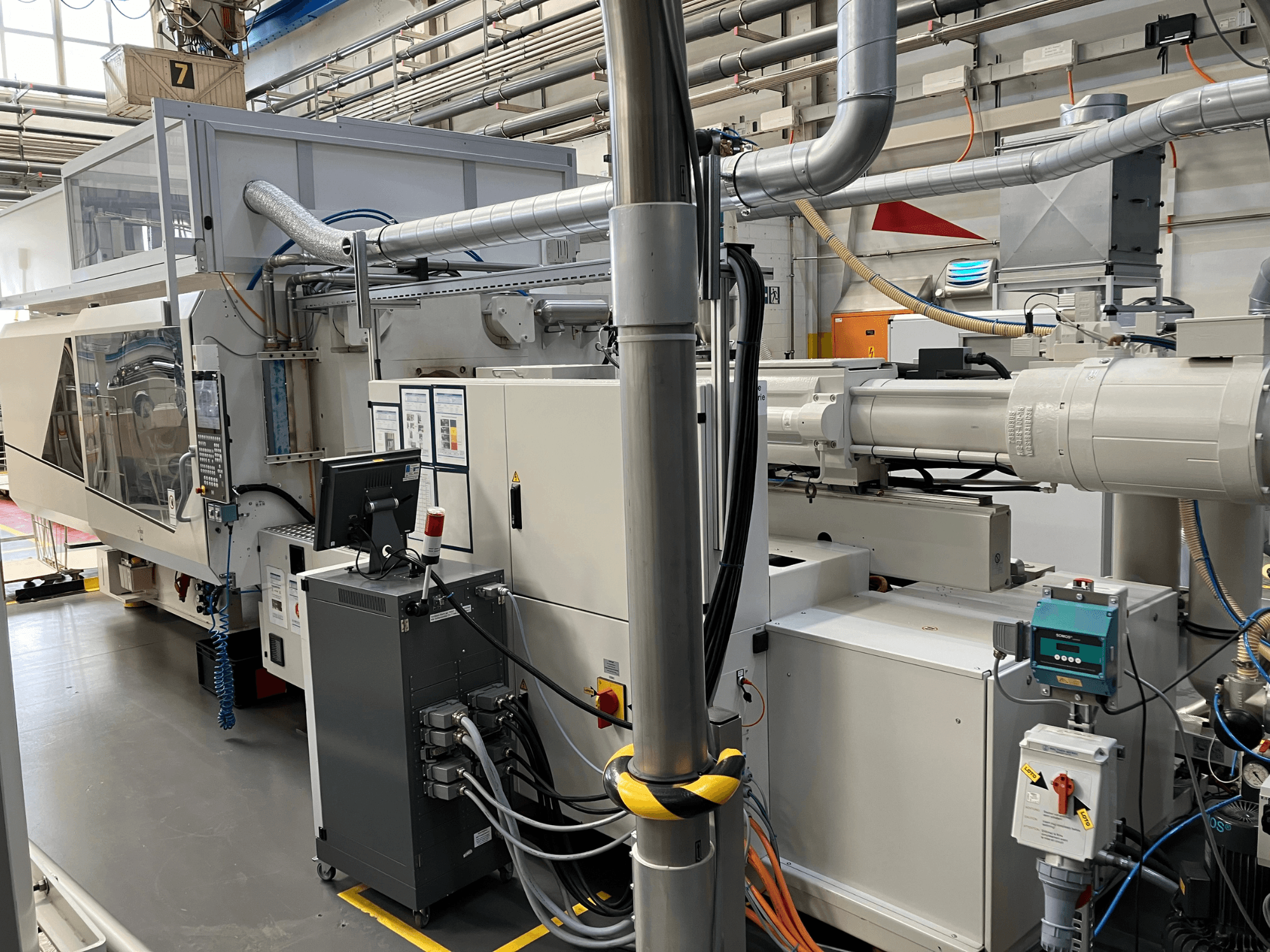 Промислове обладнання з панеллю керування, вигляд спереду, з трубами, електричними компонентами та елементами безпеки.