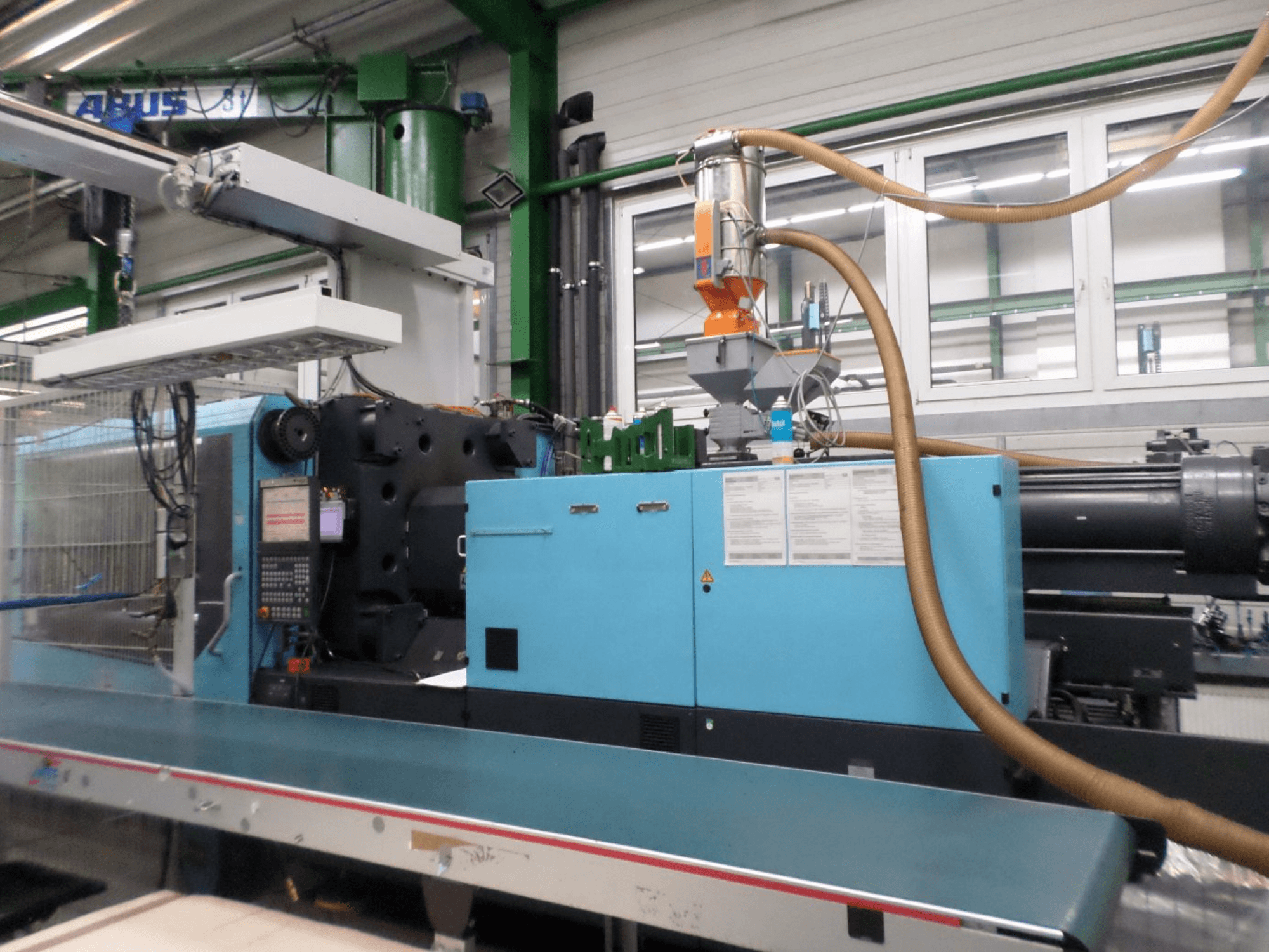 Вигляд спереду гідравлічної термопластавтомата DEMAG D 420 із панеллю управління, бункером та гідравлічними вузлами.