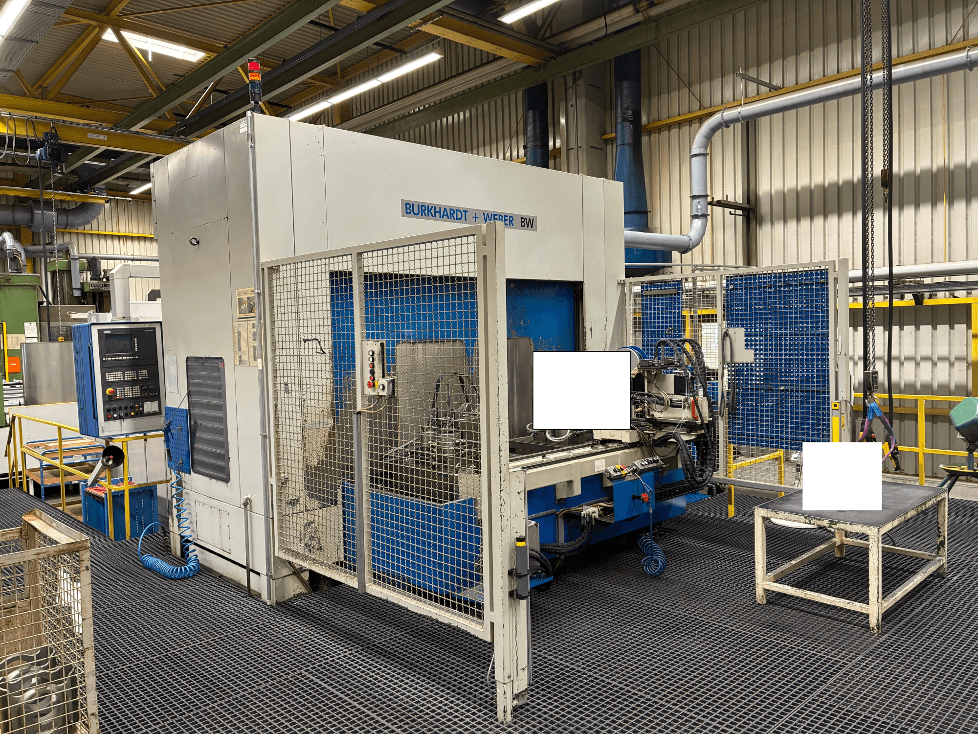 Обробний центр Burkhardt + Weber BW, вид спереду, оснащений панеллю керування та захисним кожухом, розташований в промислових умовах.