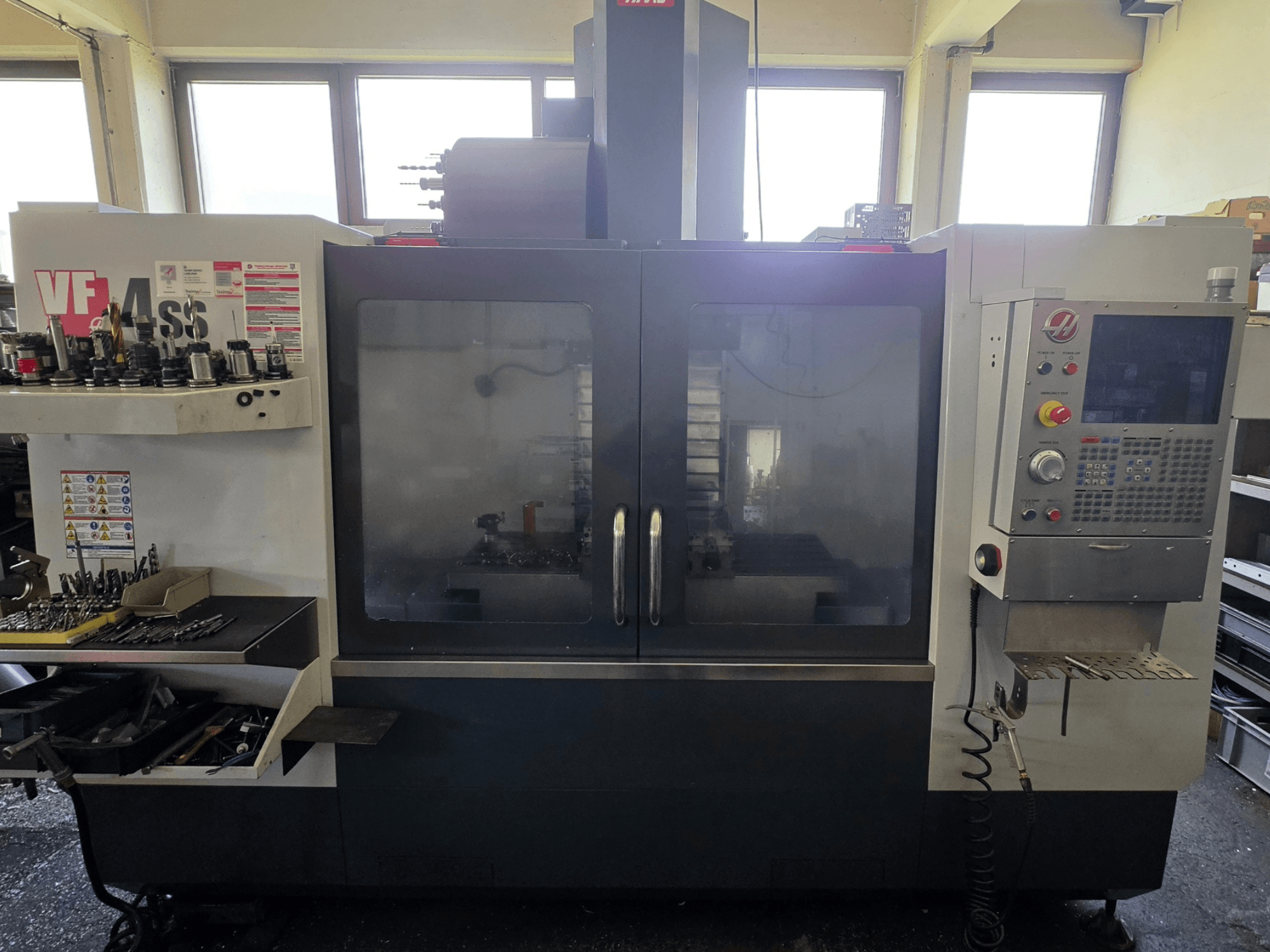 Вертикальний обробний центр HAAS VF 34SS, вид спереду, демонструє панель керування та зону зберігання інструменту.