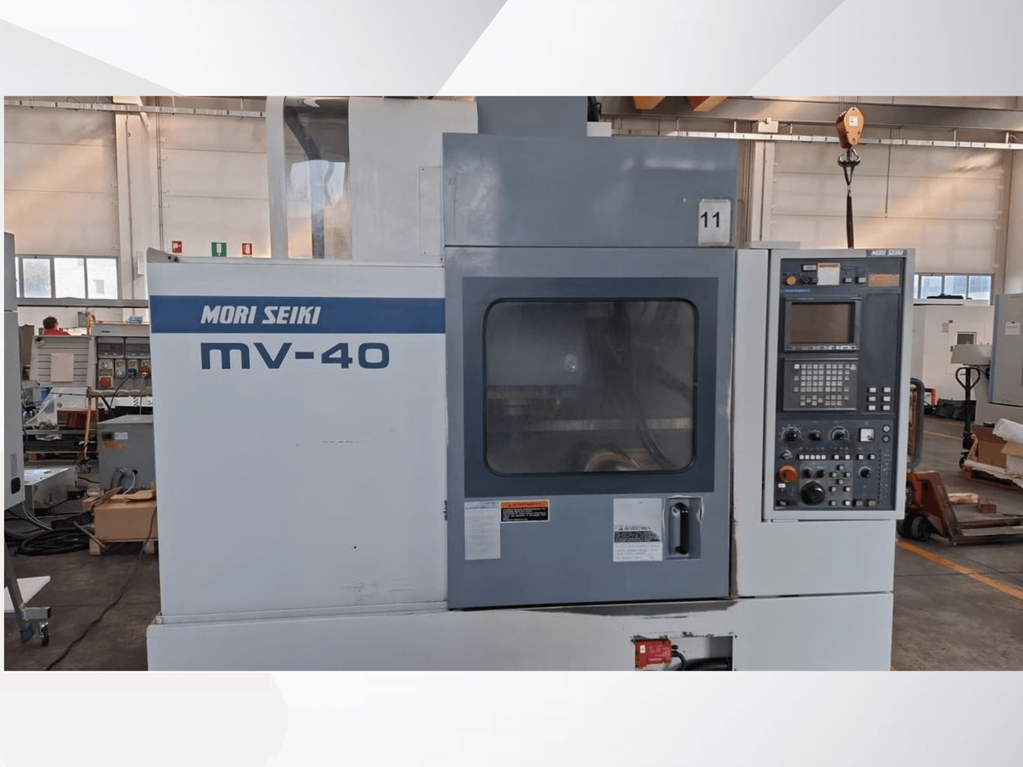 Вертикальний обробний центр MORI SEIKI MV-40, вид спереду з панеллю керування та вікном, в умовах майстерні.