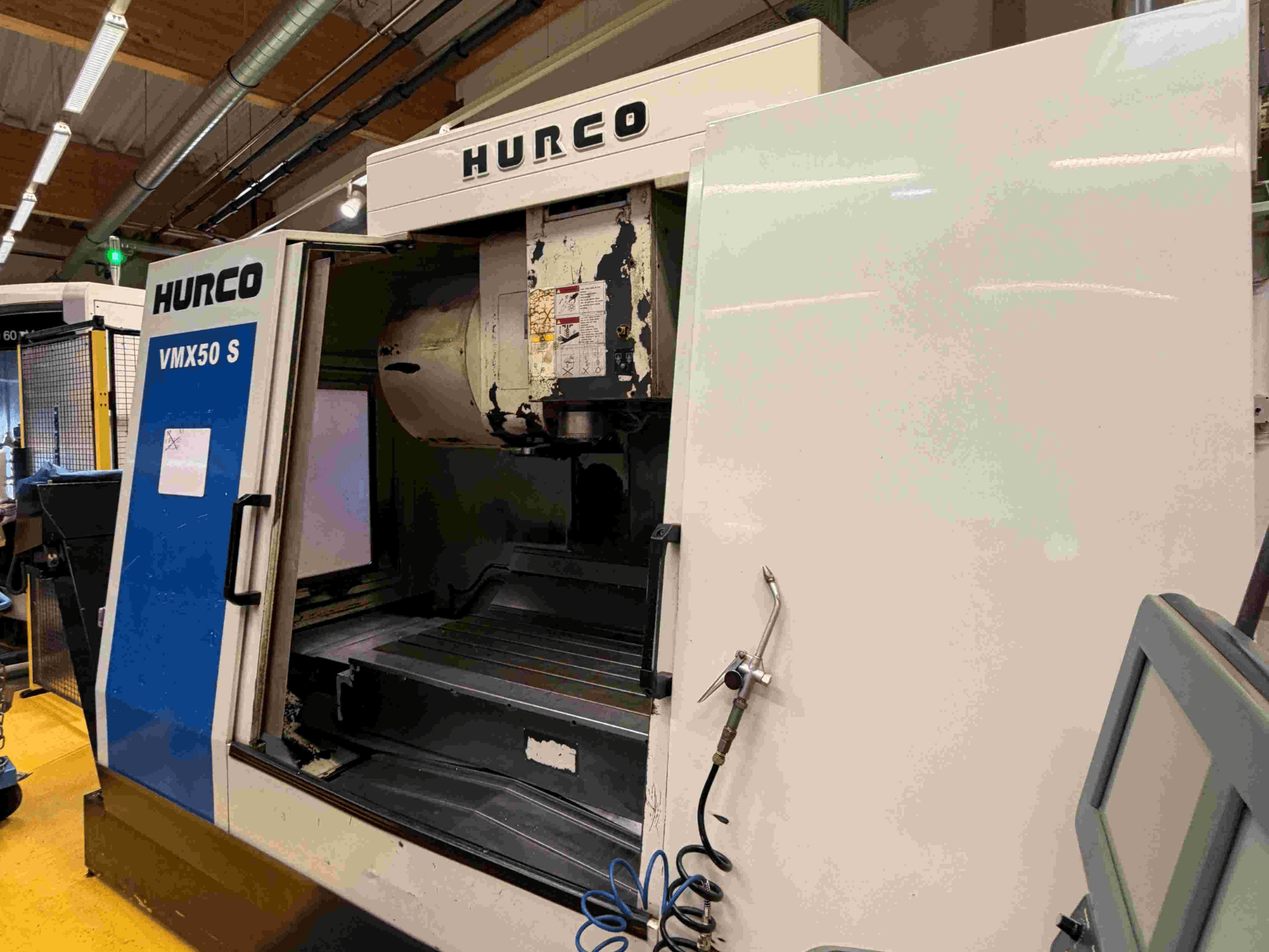 Вертикальний обробний центр Hurco VMX50 S, вид збоку, з відкритими дверцятами та панеллю керування.