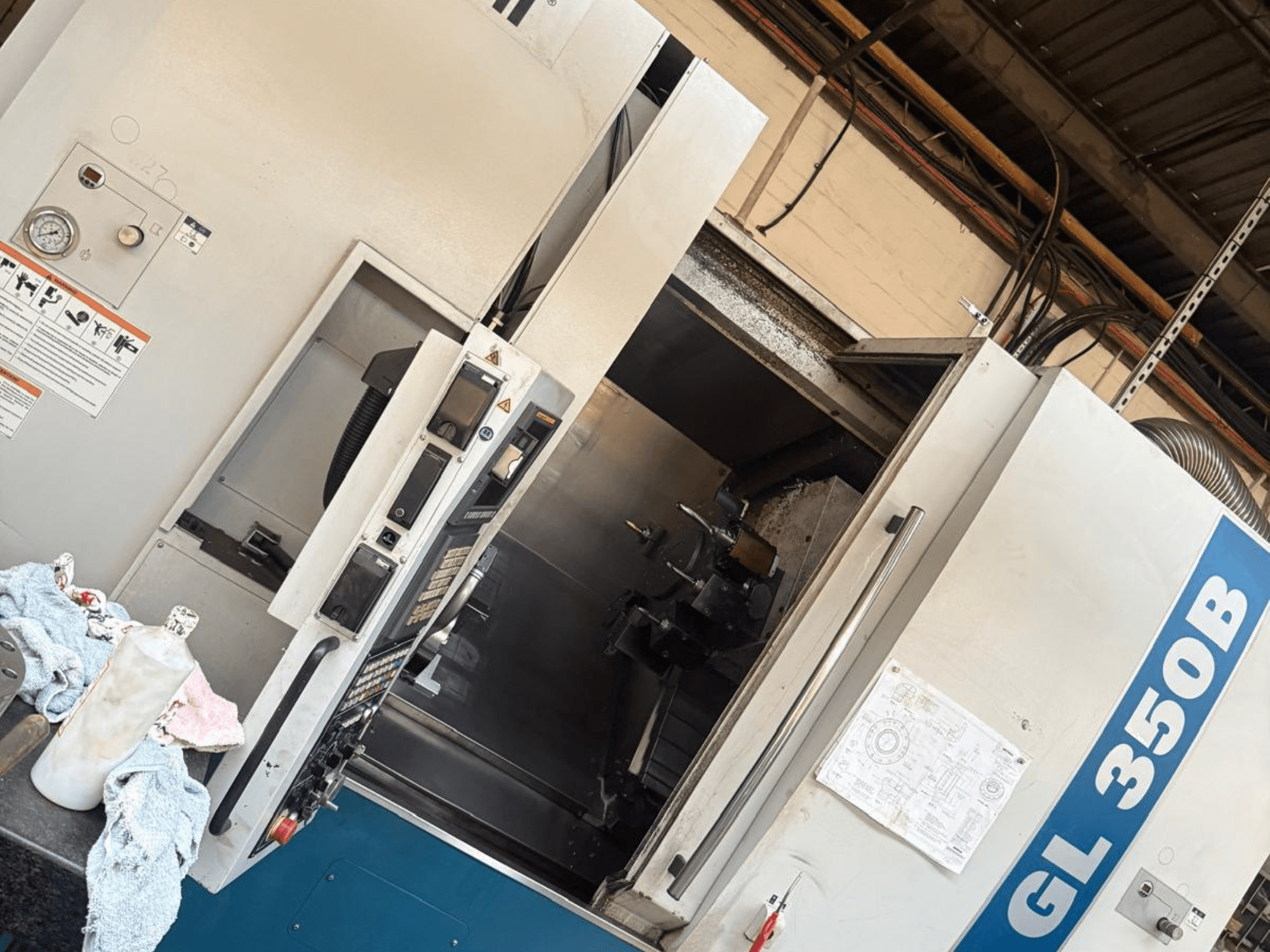 Горизонтальний токарний верстат Romi GL 350B, вид спереду, з панеллю керування та відчиненими дверцятами, що відкривають внутрішній простір.