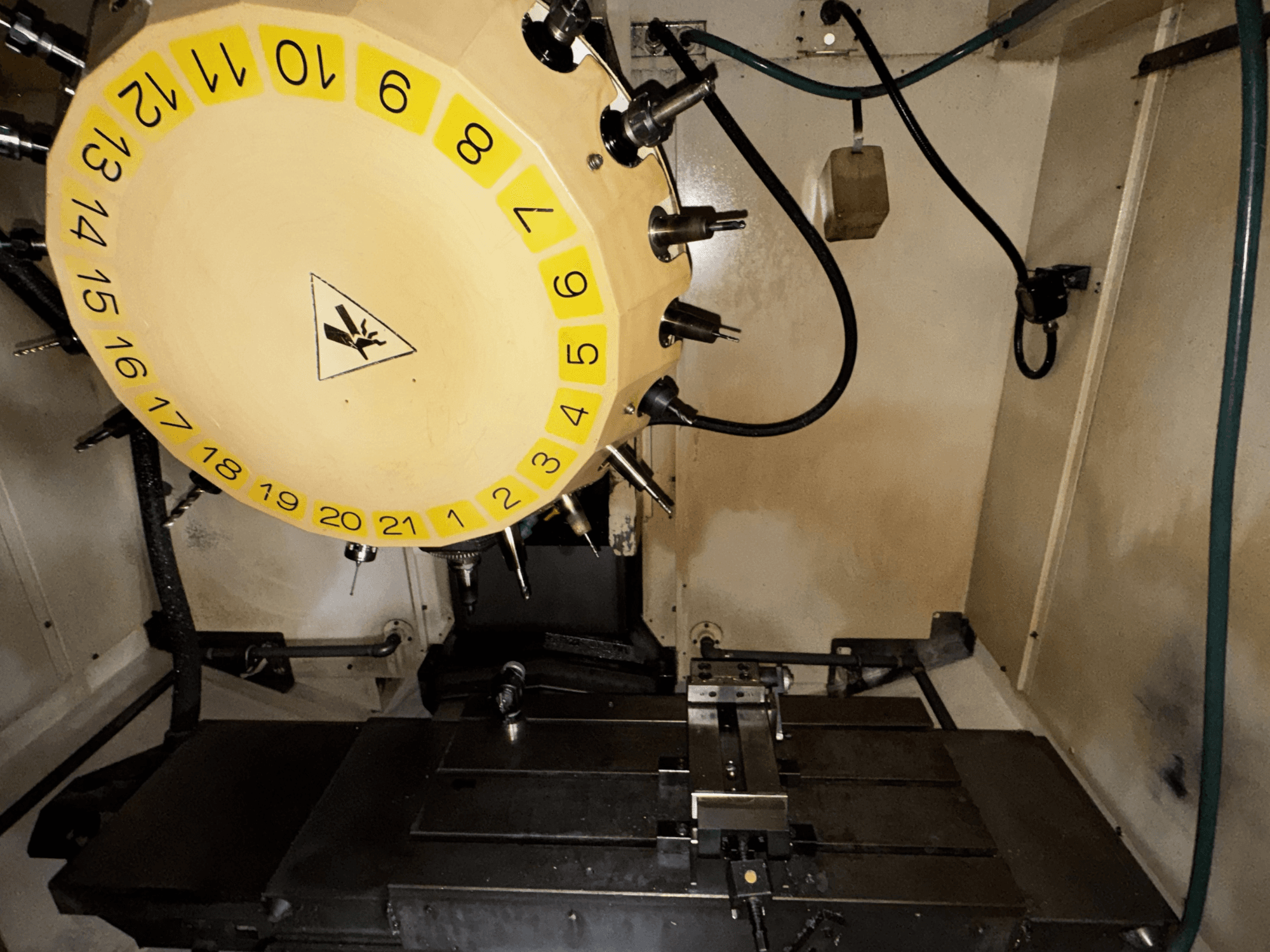 Внутрішній вигляд вертикального обробного центру FANUC Robodrill alpha-T21iFL з каруселлю інструментів і обробним столом.
