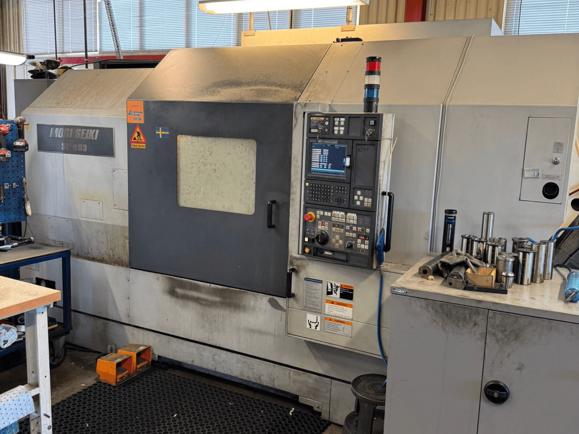 Горизонтальний токарний верстат MORI SEIKI SL-403BMC/800 в майстерні, показана панель керування та інструменти, вид збоку.
